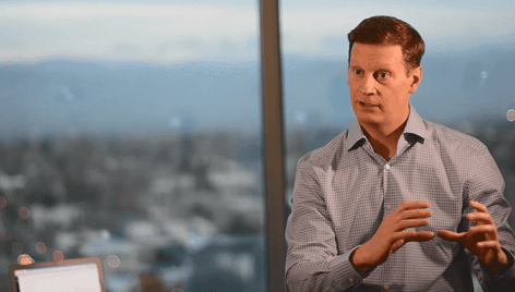 man standing behind flat screen computer monitor