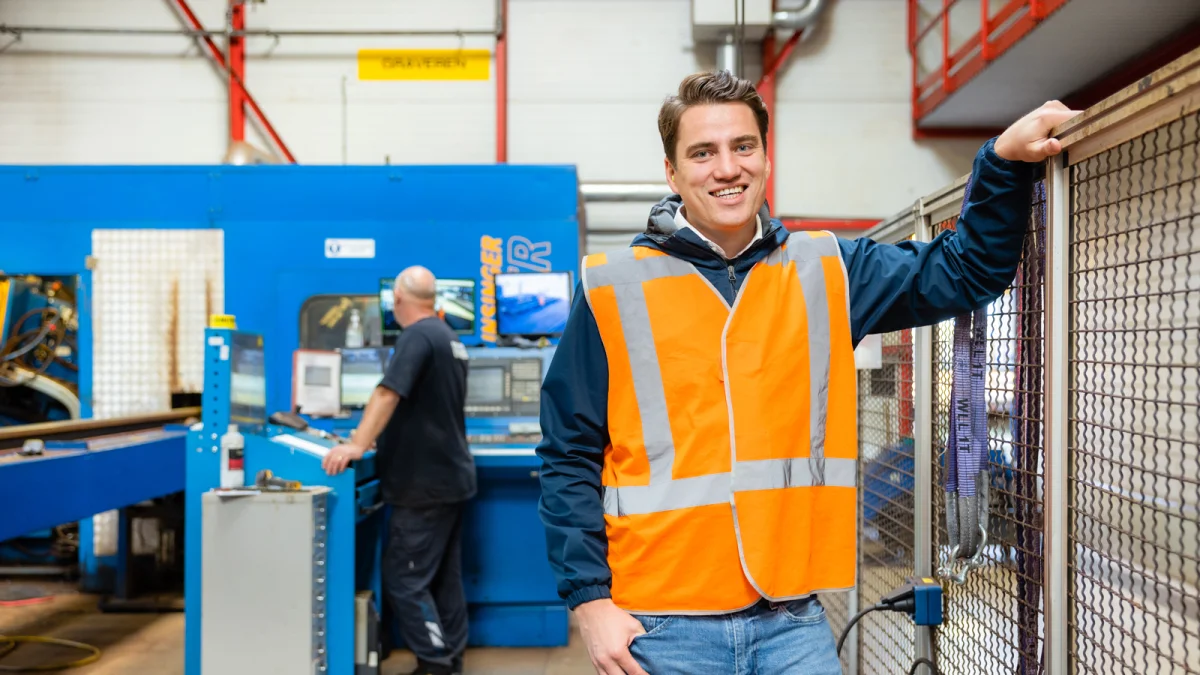 Man in een fabriek werkplaats met veiligeheidshesje aan