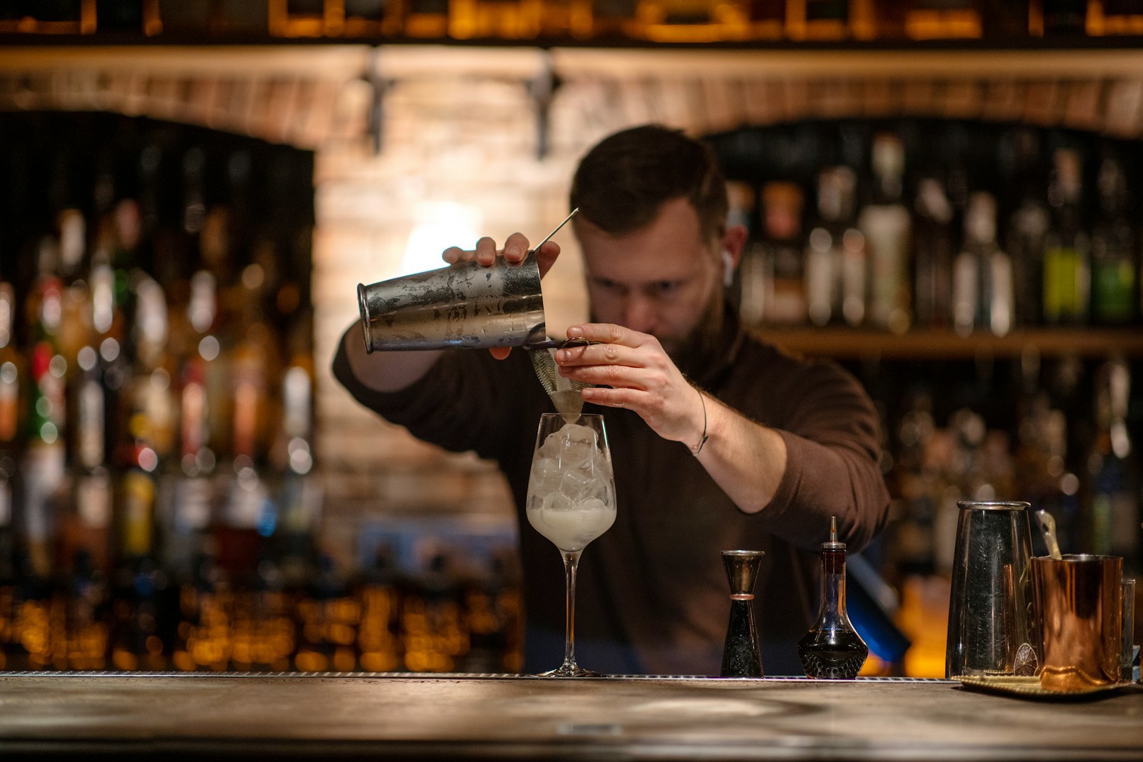 Mann mixt einen Cocktail an der Bar