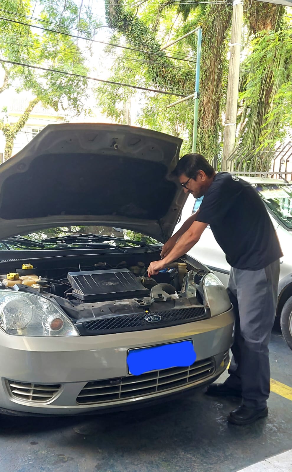 Miguel instalando uma bateria no veículo
