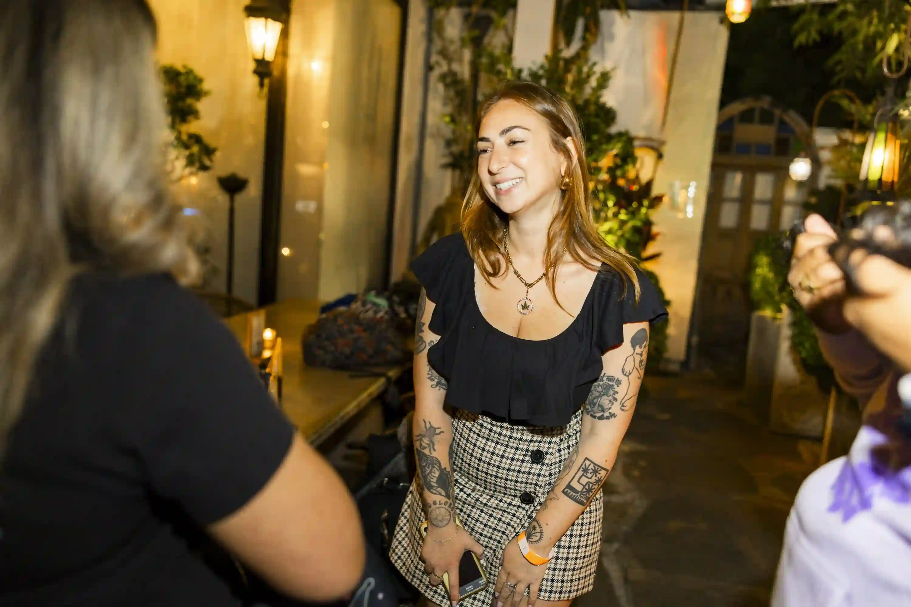 Smiling woman with tattoos at The Woods.