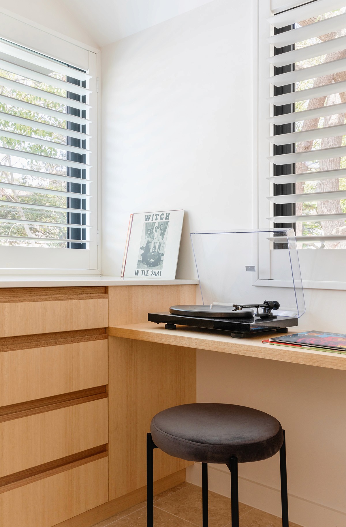Built-in study nook inside the Woollahra Treehouse, with timber joinery, operable louvre windows, and soft daylight filtering through surrounding foliage.