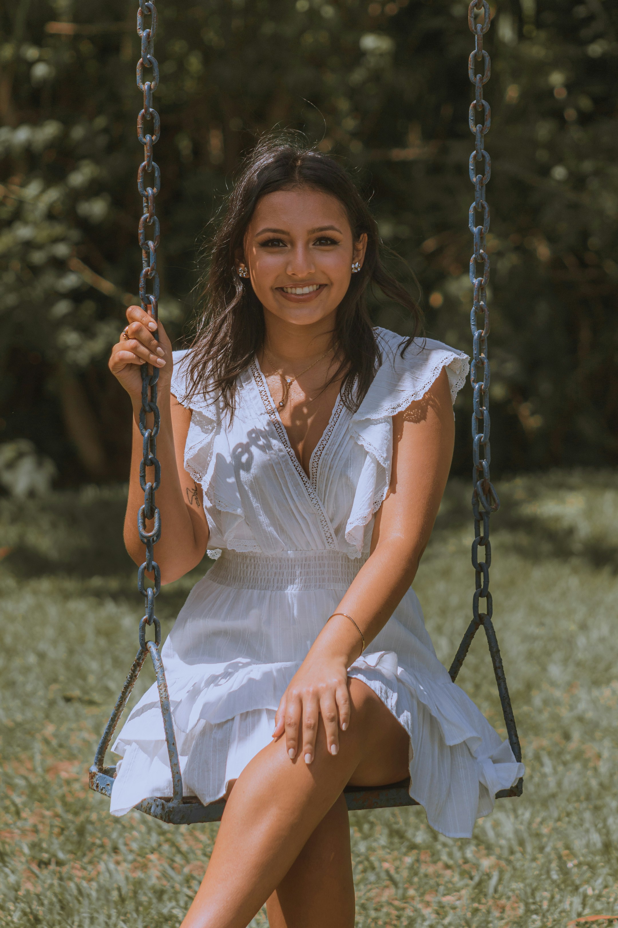 a woman wearing a white dress and gold hoop earrings