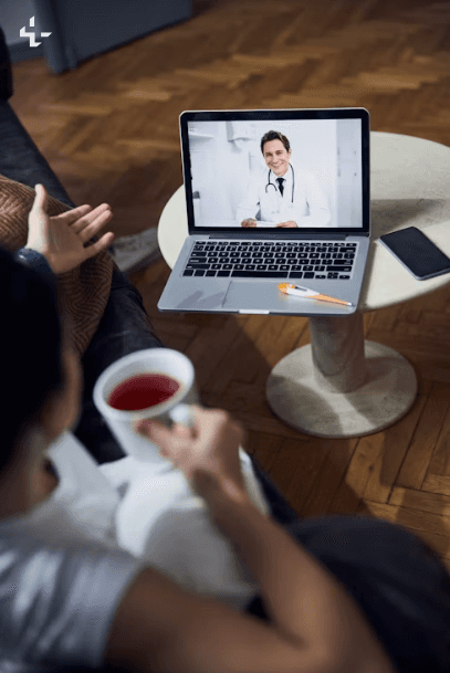 Doctor consulting patient via video call on laptop.