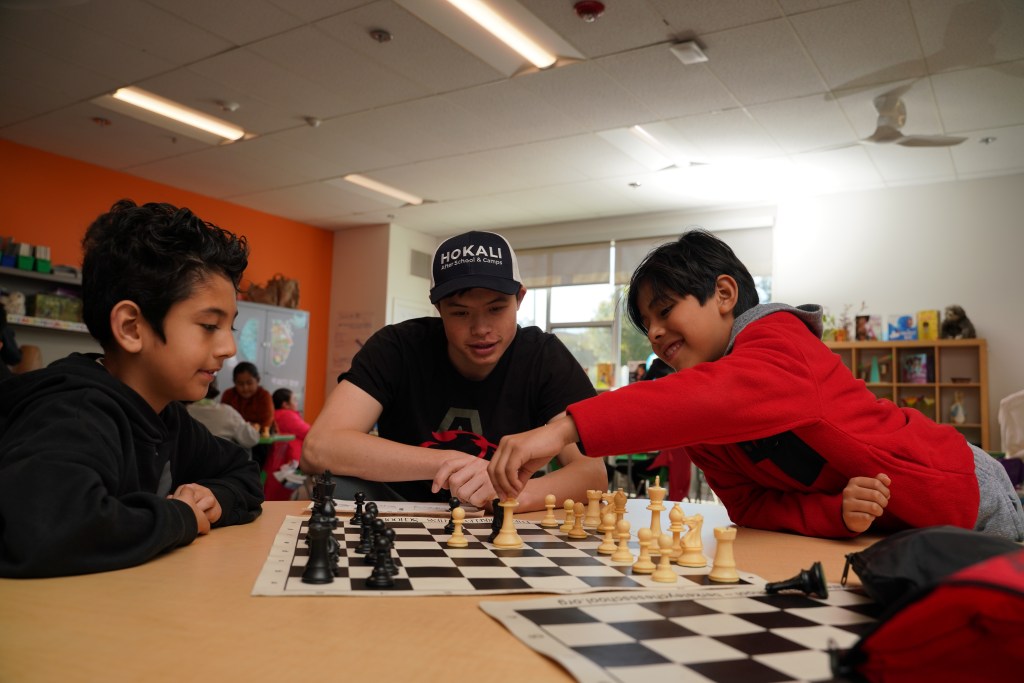 Students participating in a HOKALI after-school chess enrichment program guided by an instructor in a classroom setting