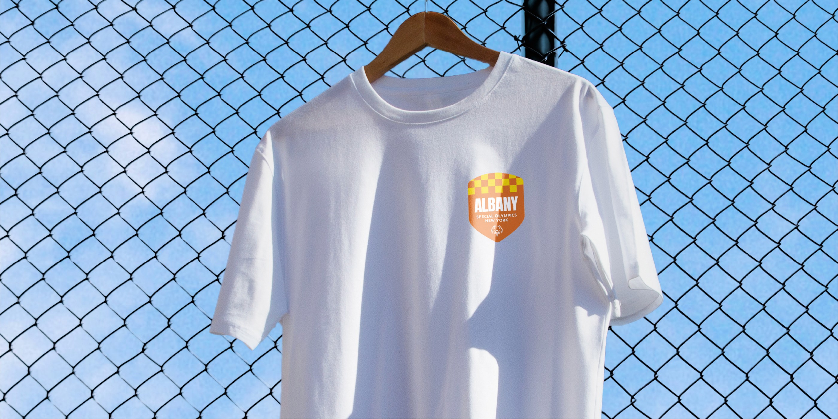 T-shirt hanging on a fence with a badge on the front