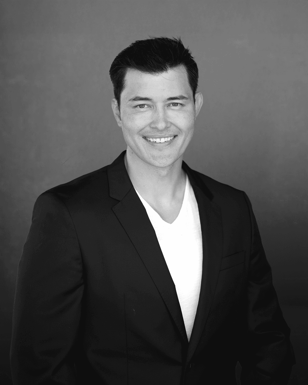 man in black suit standing in front of people