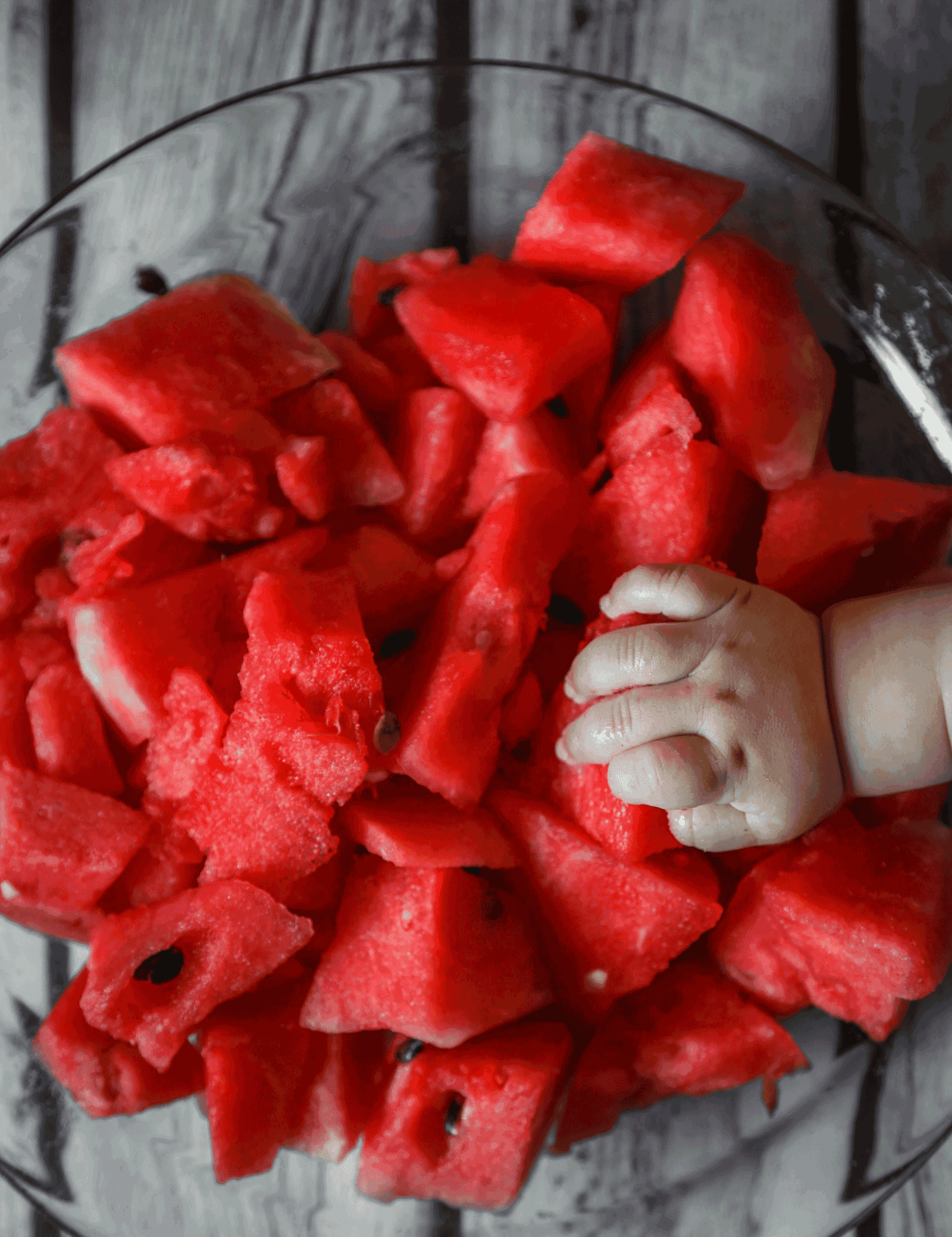 Baby Led Weaning - Eine Babyhand greift in eine Schüssel mit Melonen