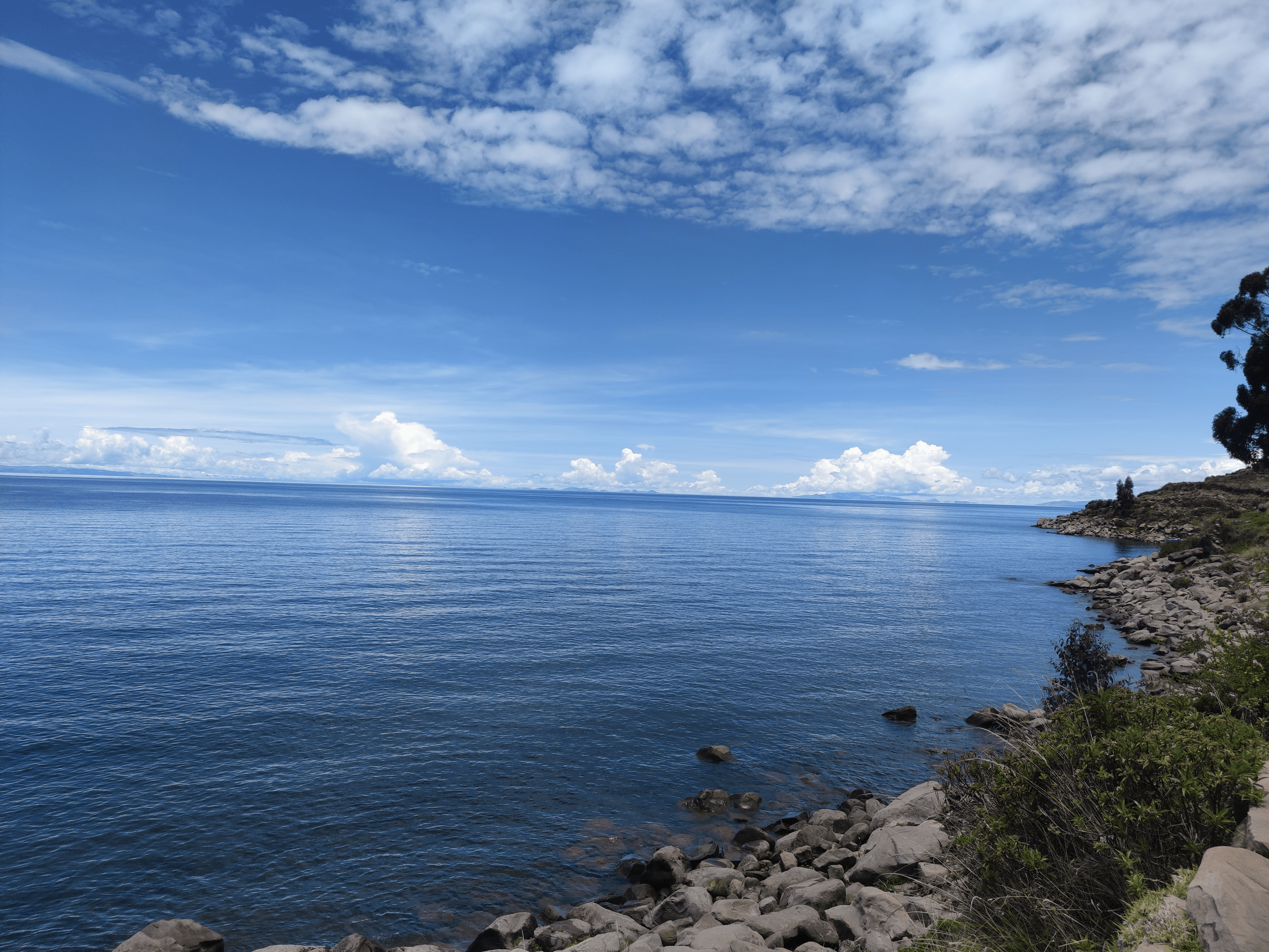 two people in separate kayaks navigate a rocky shoreline