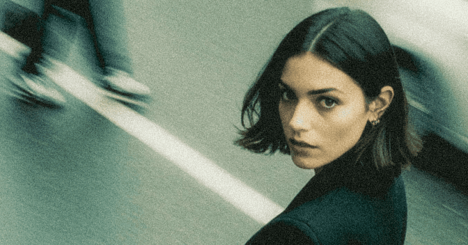 Female model wearing corporate clothes standing in the middle of the street with a motion blur backgorund