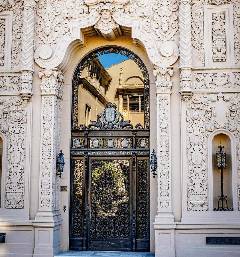 Ornate stone archway with a decorative metal door, reflecting a beautiful architectural detail.