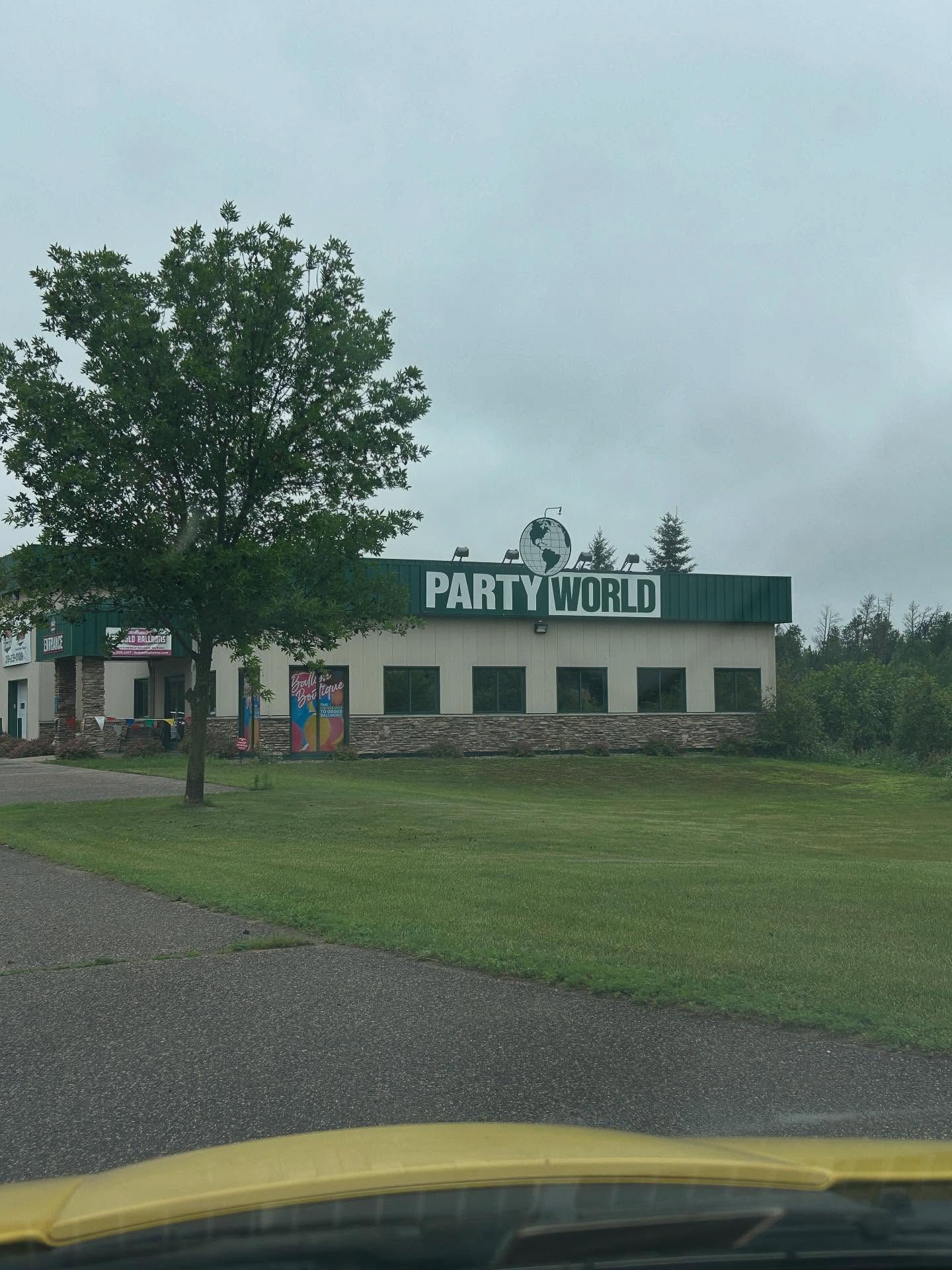 Exterior view of a white commercial building with grassy surroundings used for Be Bold Balloons operations or event setup