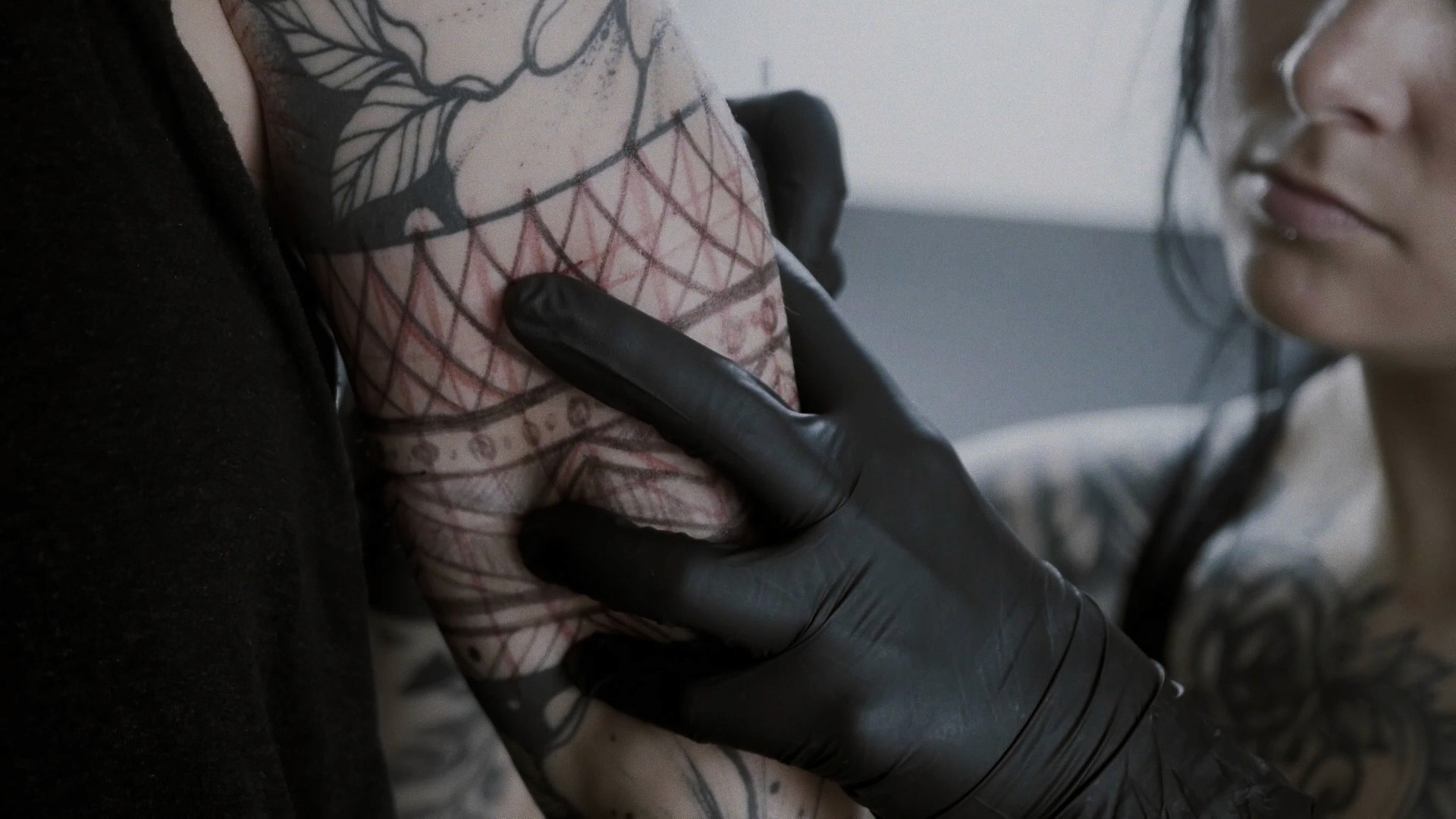 Cinematic art film frame of Yanina Viland working on a detailed tattoo