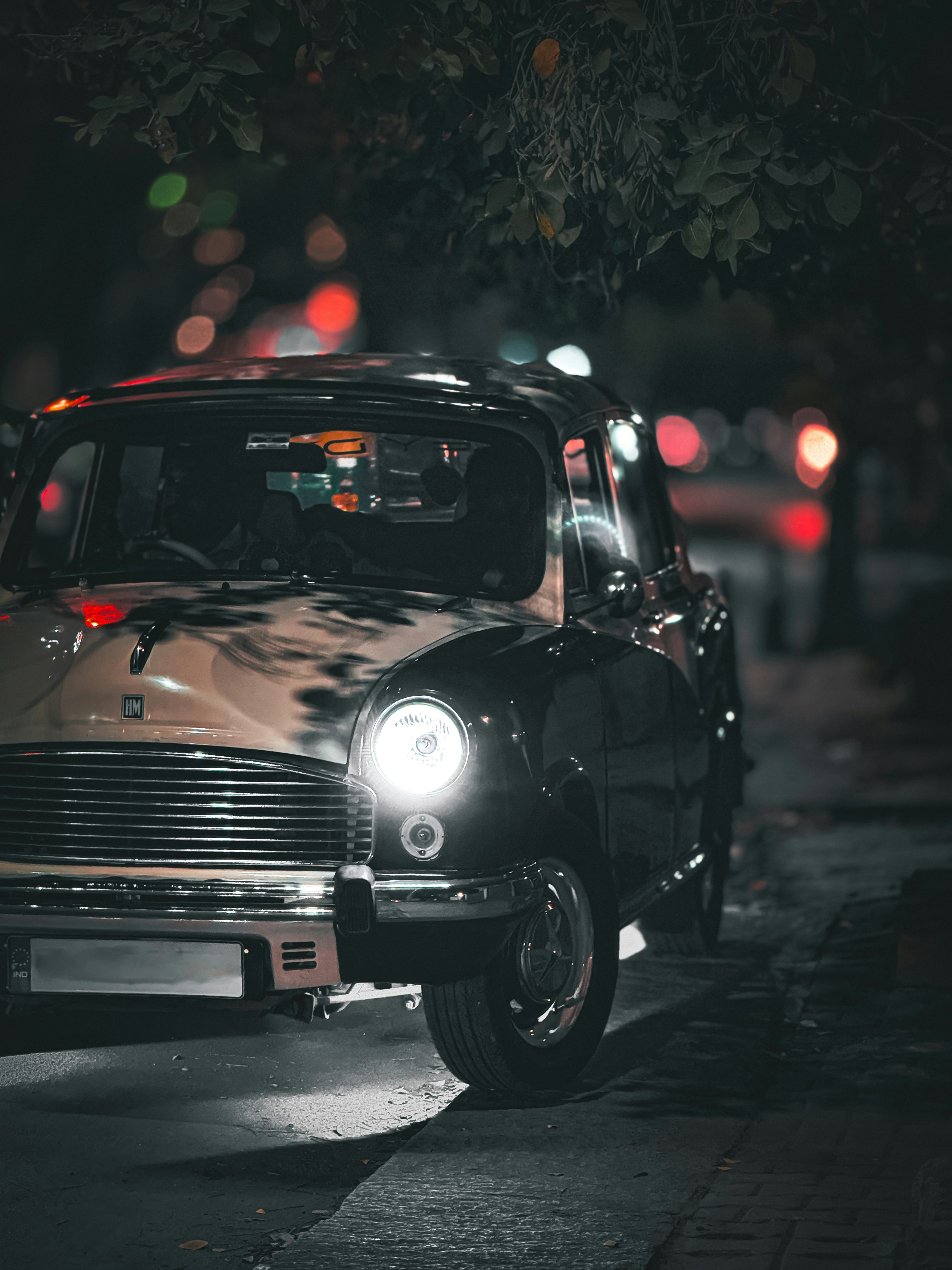 A car parked on the side of the road at night