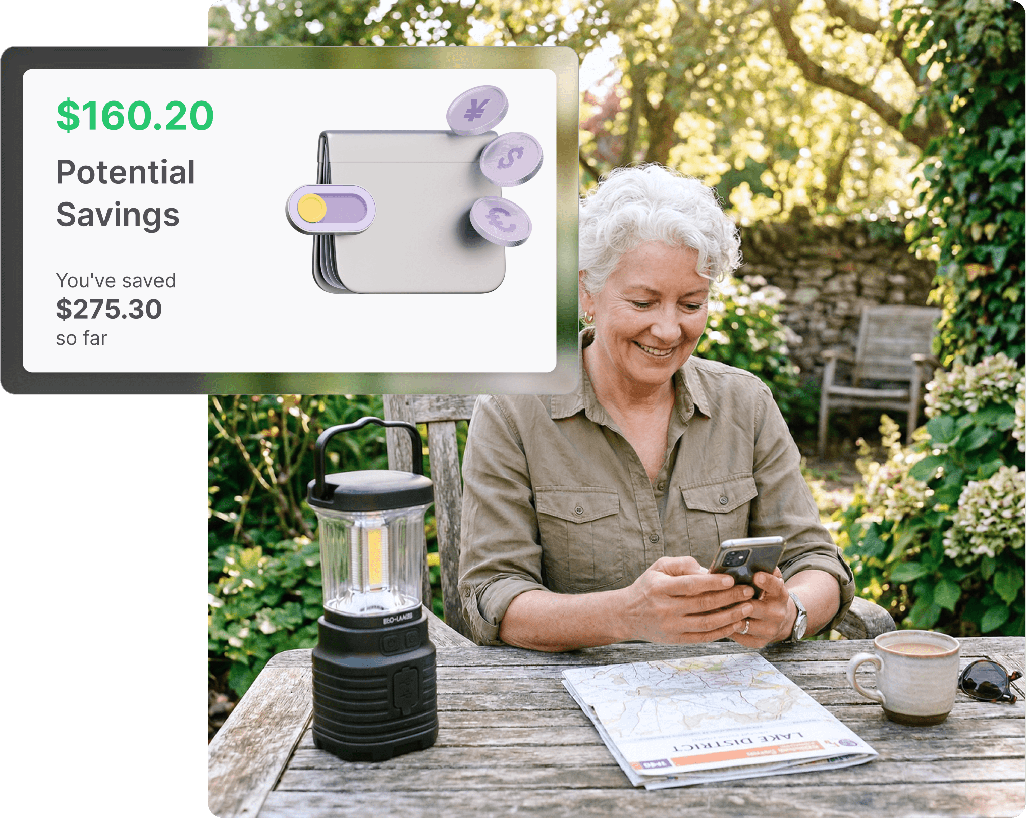 Older woman sitting at an outdoor garden table smiling at her phone, with a Kmart-style camping lantern and a map beside her, viewing her Whisprice savings summary.