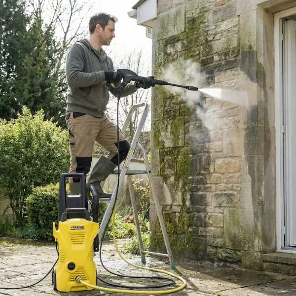 Artisan réalisant le démoussage d'une toiture et le nettoyage d'une façade à Bergerac.