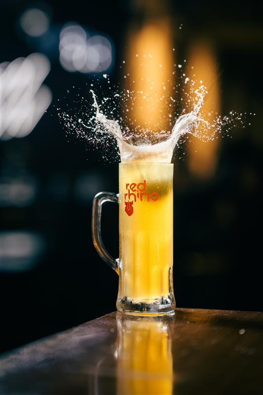 Fresh Red Rhino beer being poured into a tall glass