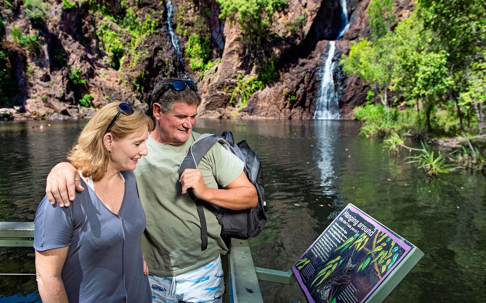 Couple reading sign at waterfall in Litchfield National Park, Darwin day tour.