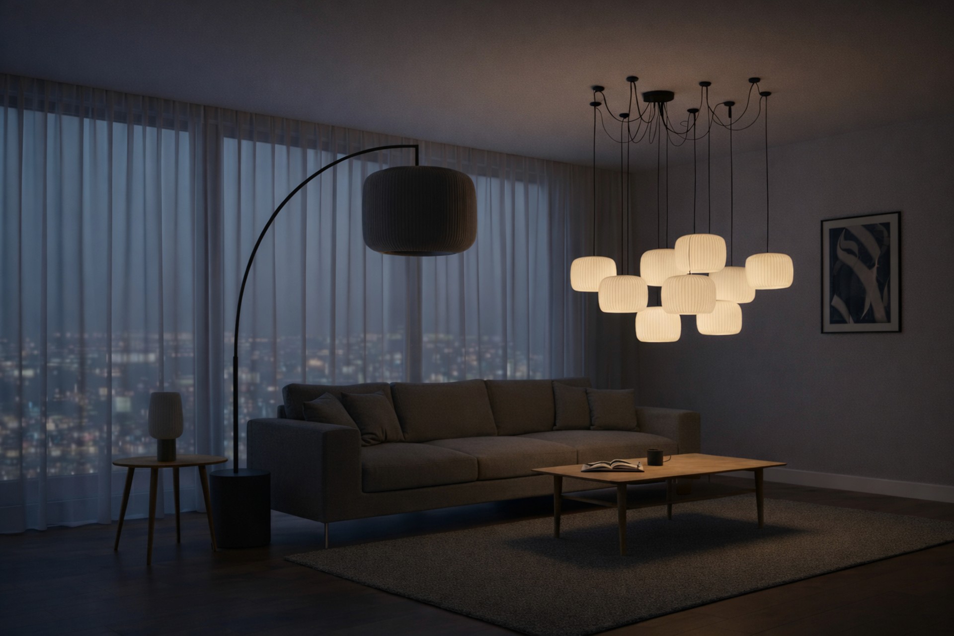 Modern living room at night featuring a glowing cluster of lantern-style pendant lights over a grey sofa and wooden coffee table, with a blurred city skyline visible through sheer curtains.