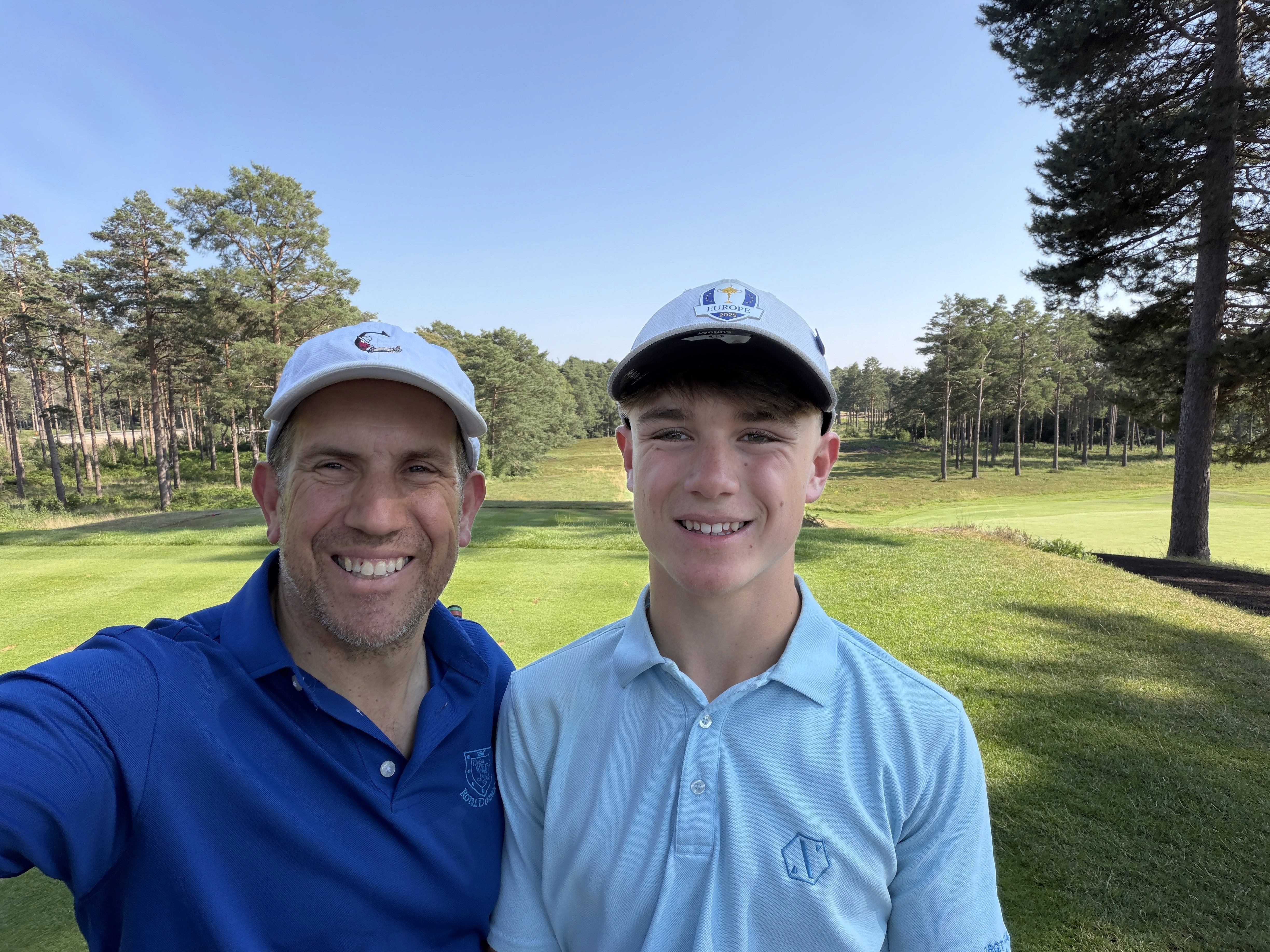 Nev Davies and teenage golfer smiling together on a golf course