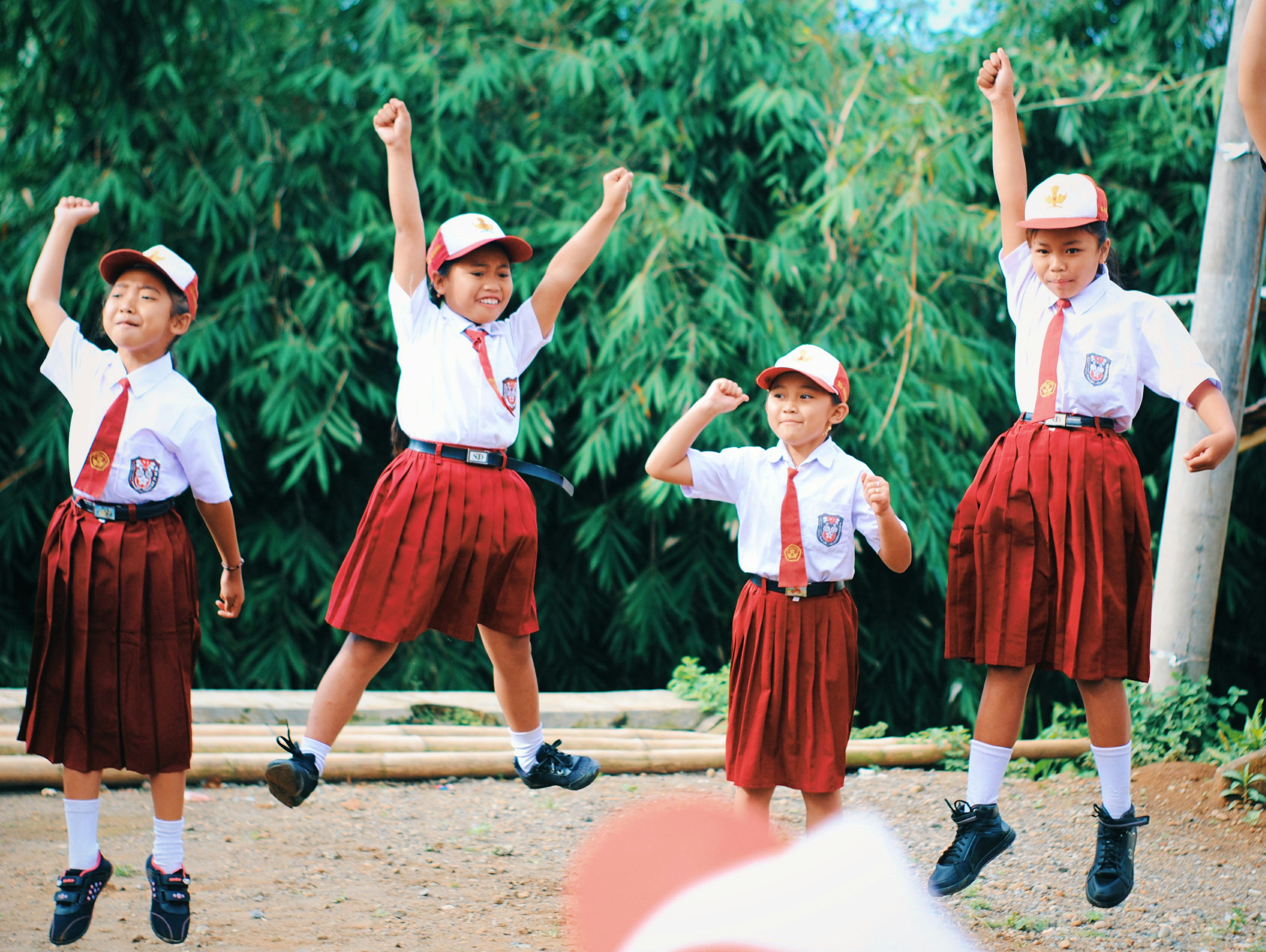group of women in red and white dress standing on brown wooden bar during daytime