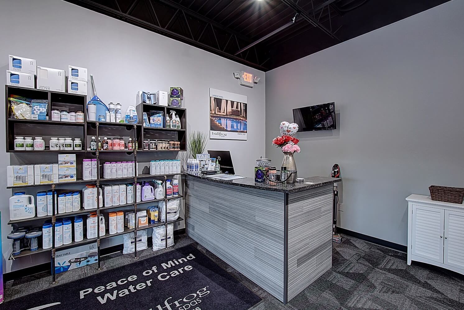 A modern reception desk in a sleek office, with shelves displaying various products and a comfortable ambiance.