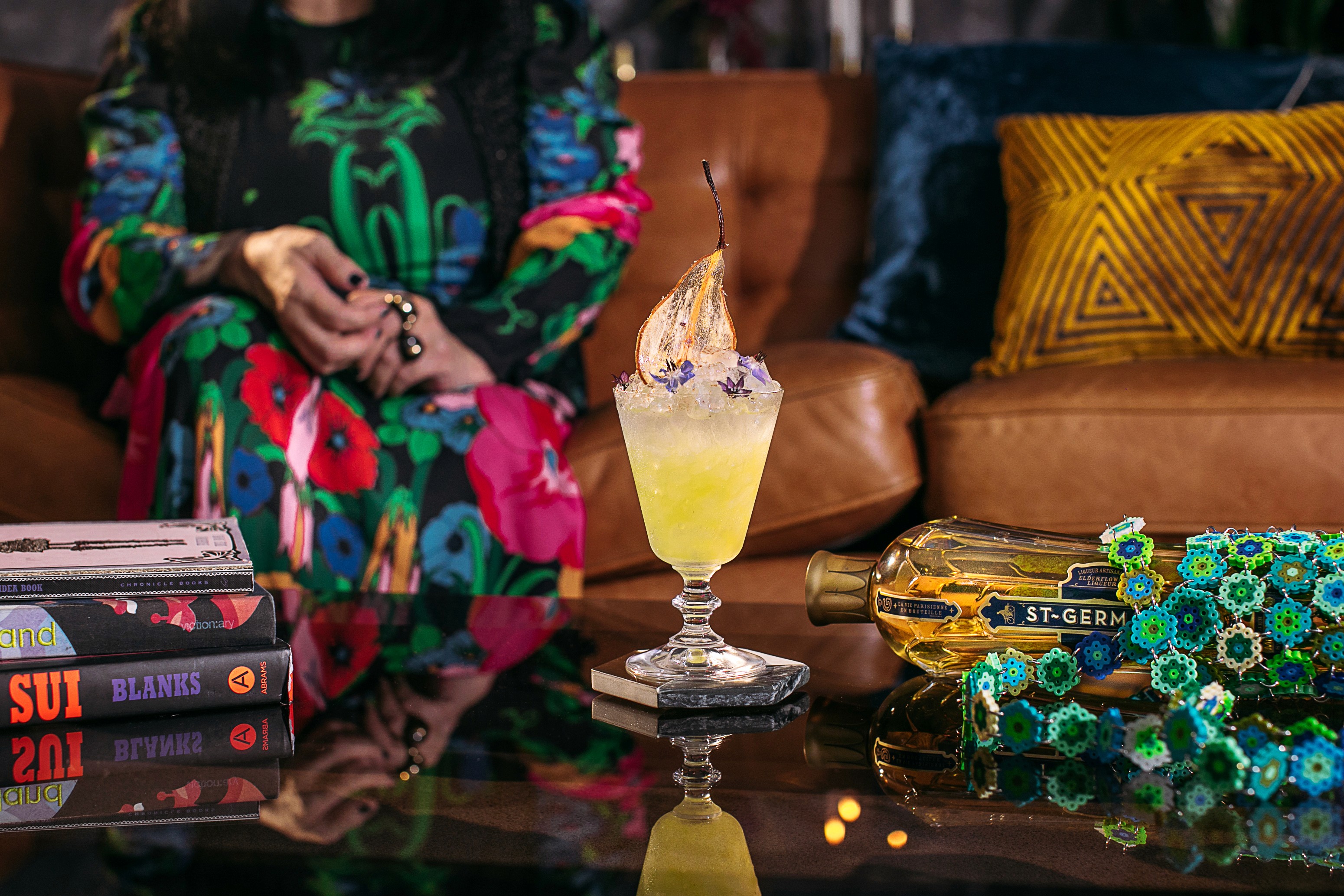 St-Germain cocktail and floral bottle tote in Anna Sui’s patterned lounge setting