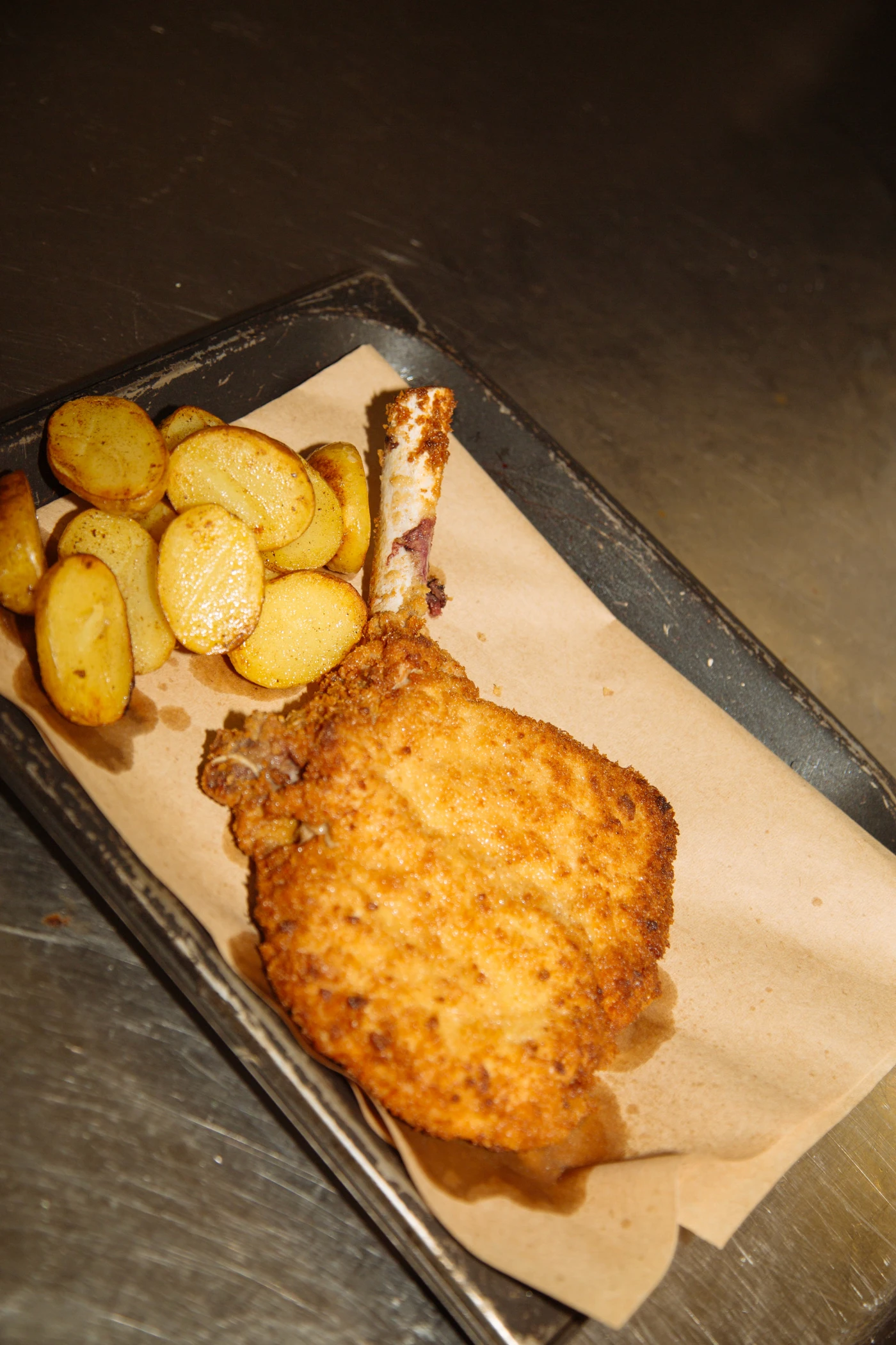 Costoletta di vitello alla milanese con patate arrosto servita al Ristorante Unico di Cantù, specialità della tradizione italiana.