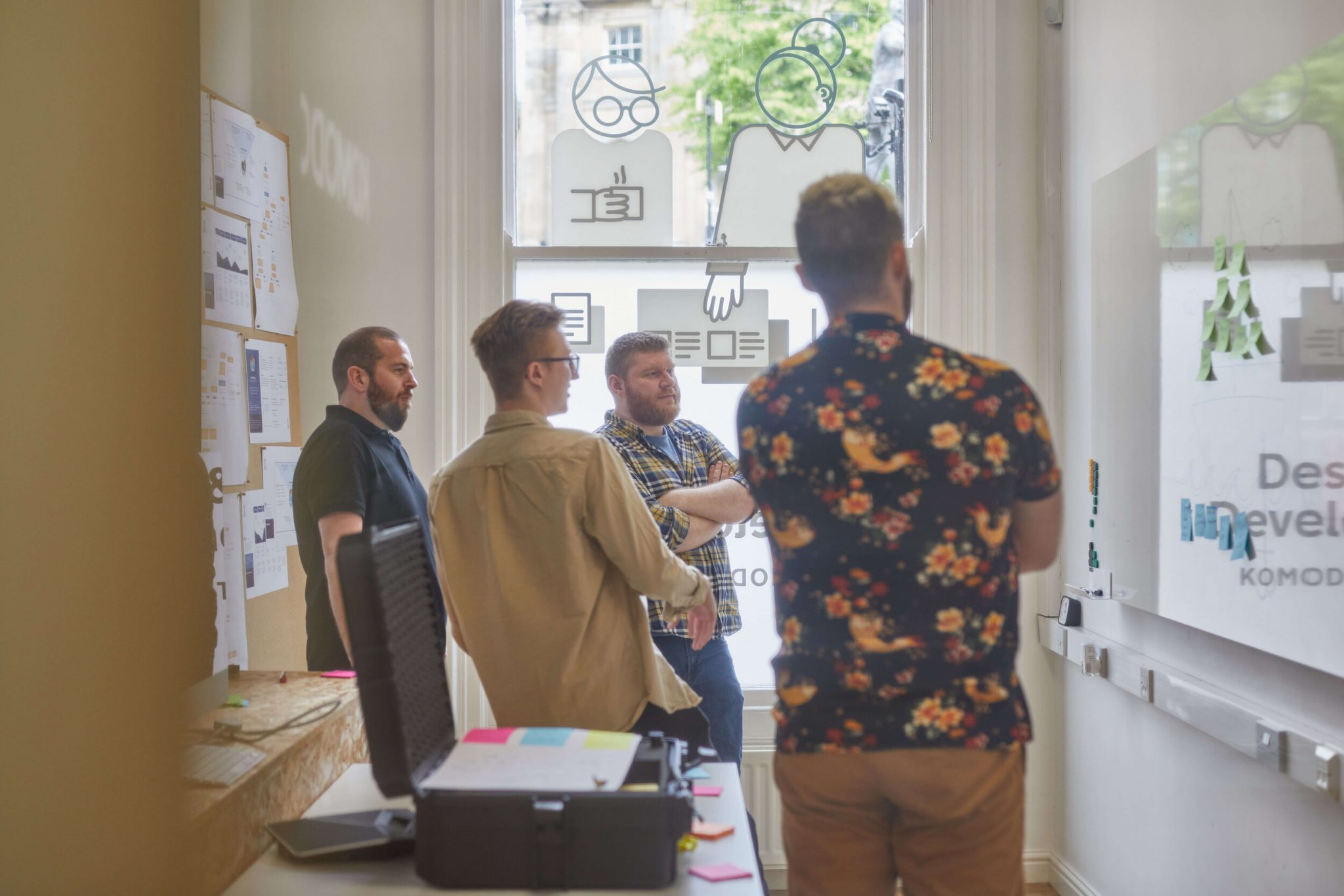 The team having a discussion while looking at the whiteboard in the Komodo studio