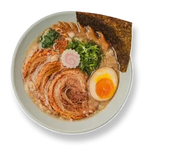Bowl of ramen with sliced chashu pork, a soft-boiled egg, green onions, nori seaweed, and a pink-swirled fish cake.