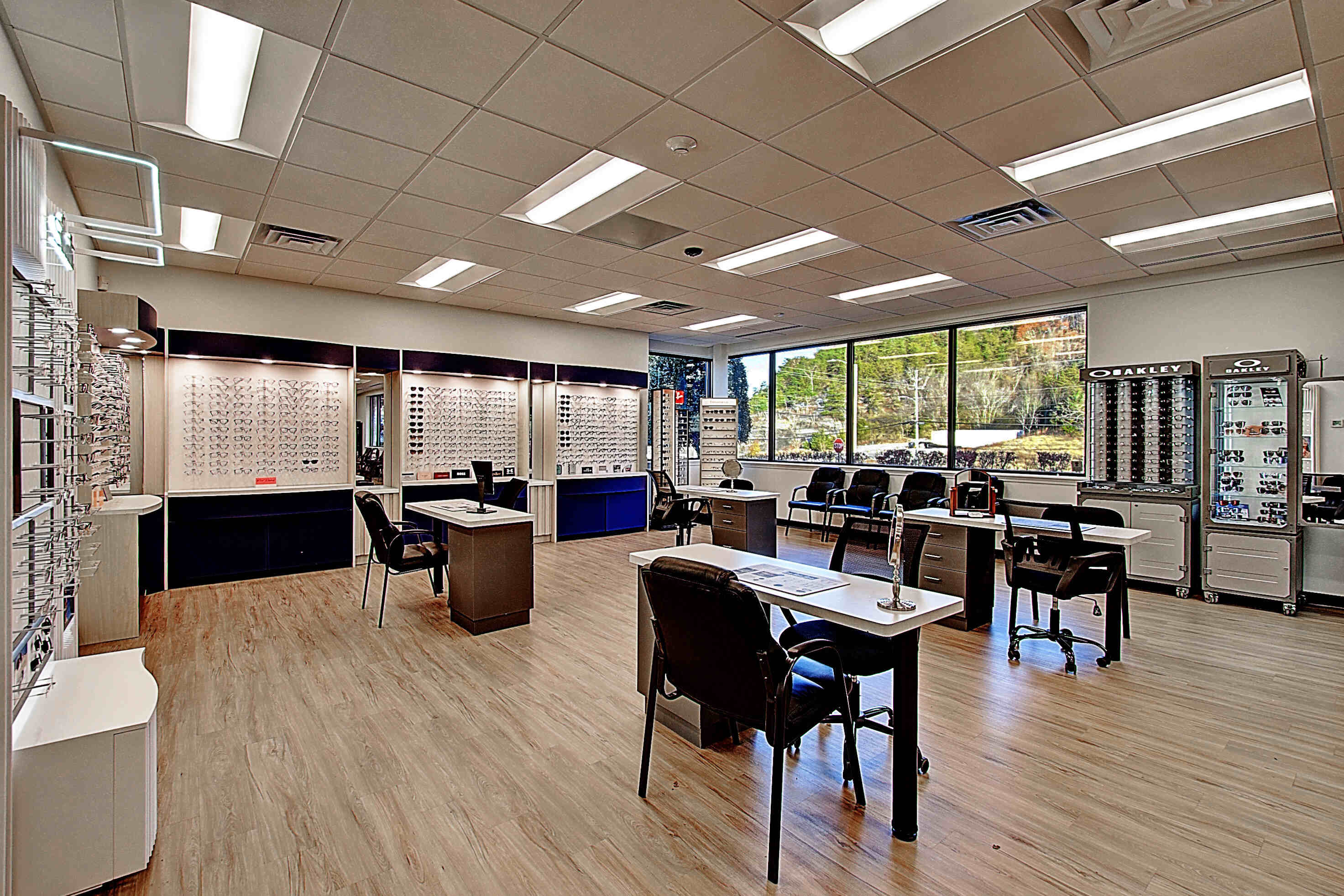 A spacious retail space featuring desks, chairs, and windows with natural light