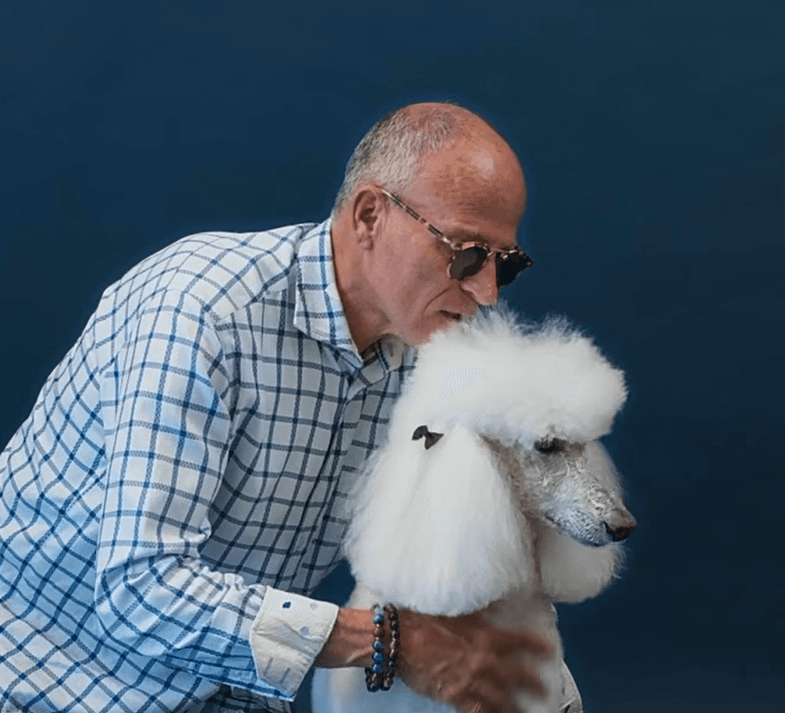 Older man embracing his white dog with a smile to capture trust, companionship, and long-term client care.