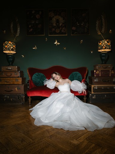 Mireasă în rochie voluminoasă albă, așezată în fotoliu verde vintage cu decor auriu — fotograf nuntă editorial București