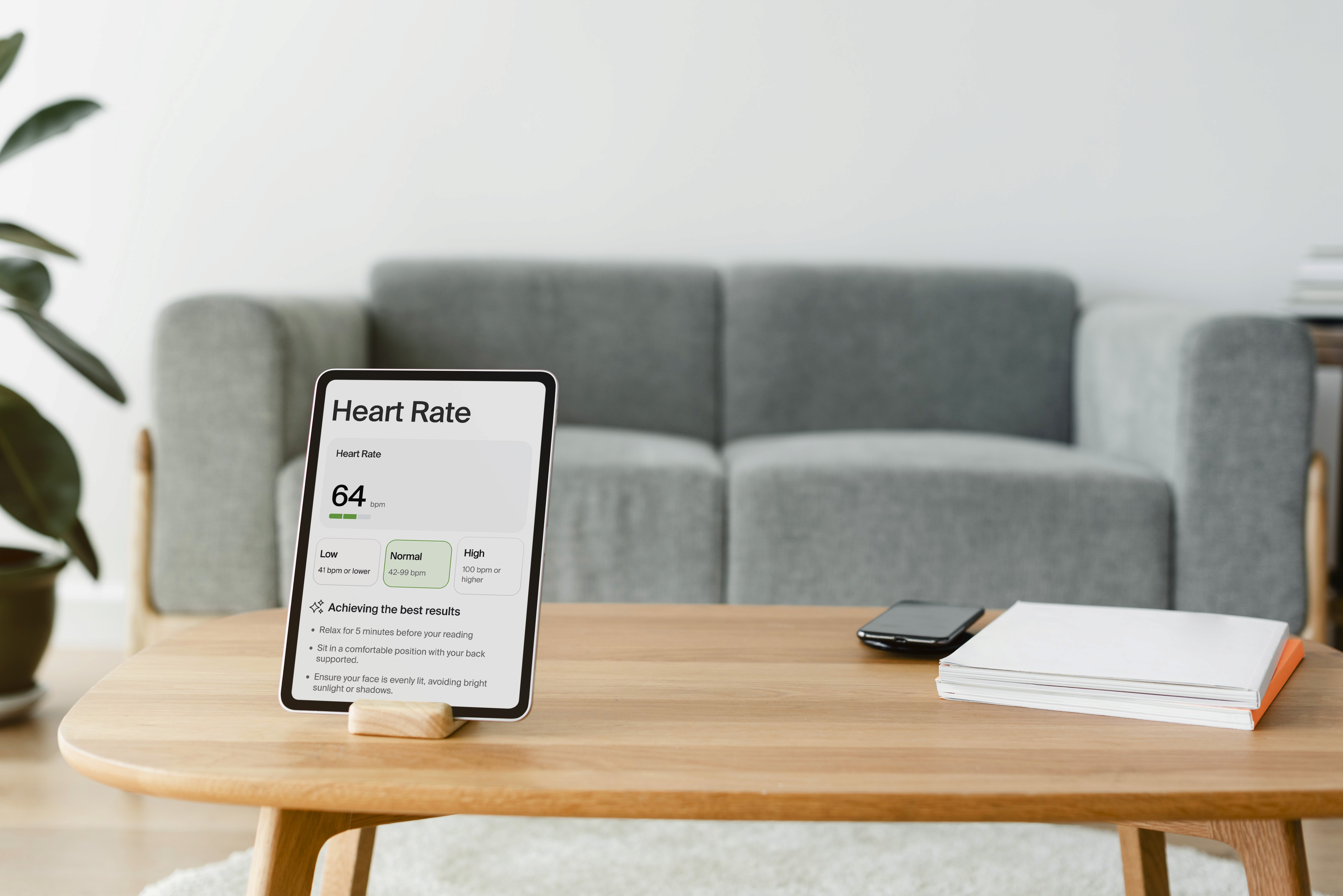 An iPad on a wooden stand in a living room, showing normal Heart Rate results.