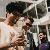 Students smiling while looking at a piece of hardware in their hand.