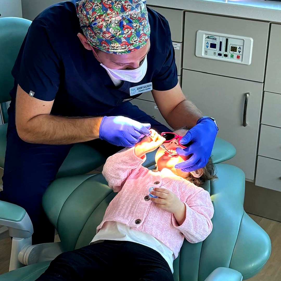 Friendly pediatric dental cleaning in Bolton for a smiling young girl.