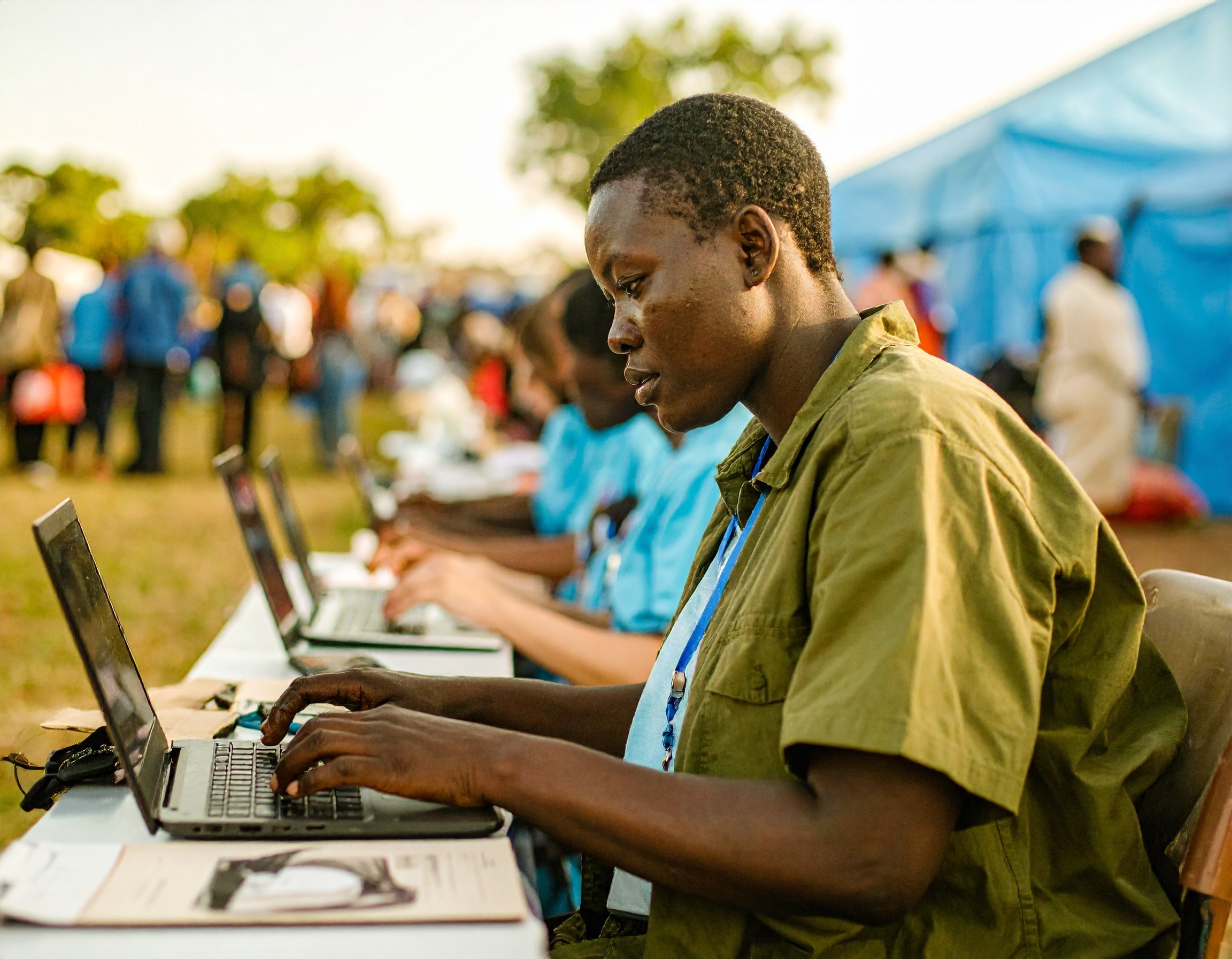 people typing at a pop up tech station