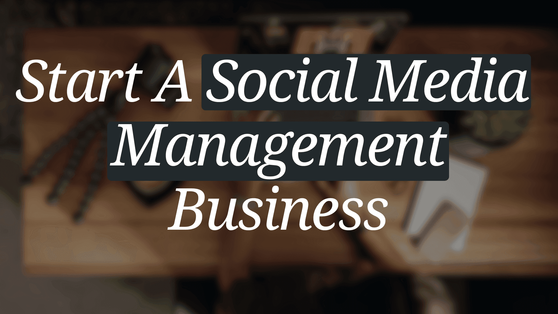  A wooden table with office supplies and a computer. Text on the image reads "Start A Social Media Management Business" in large white letters.