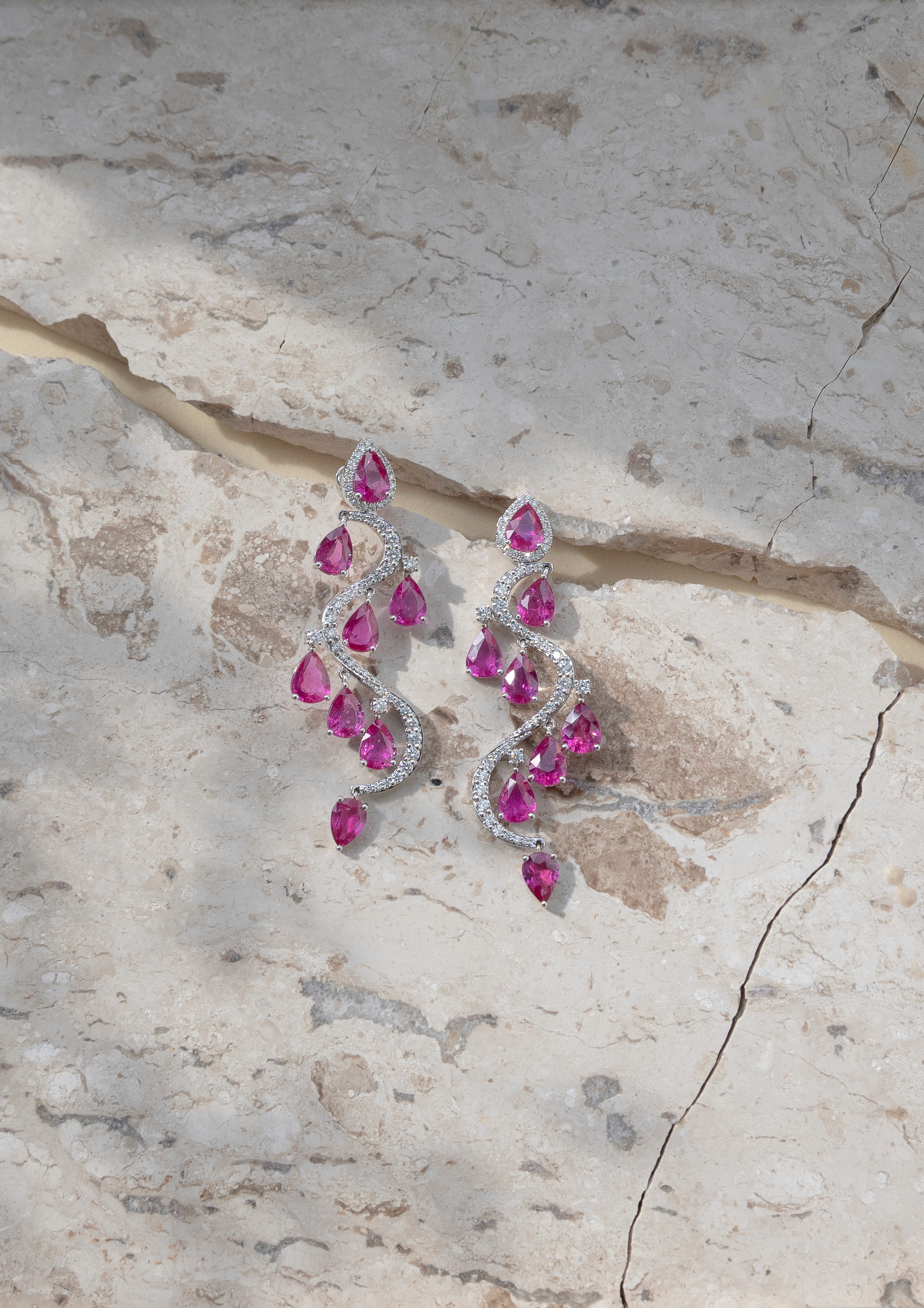 S-Curve Ruby earrings in 18k white gold, pear-shaped Mozambique rubies falling through a diamond-set curve