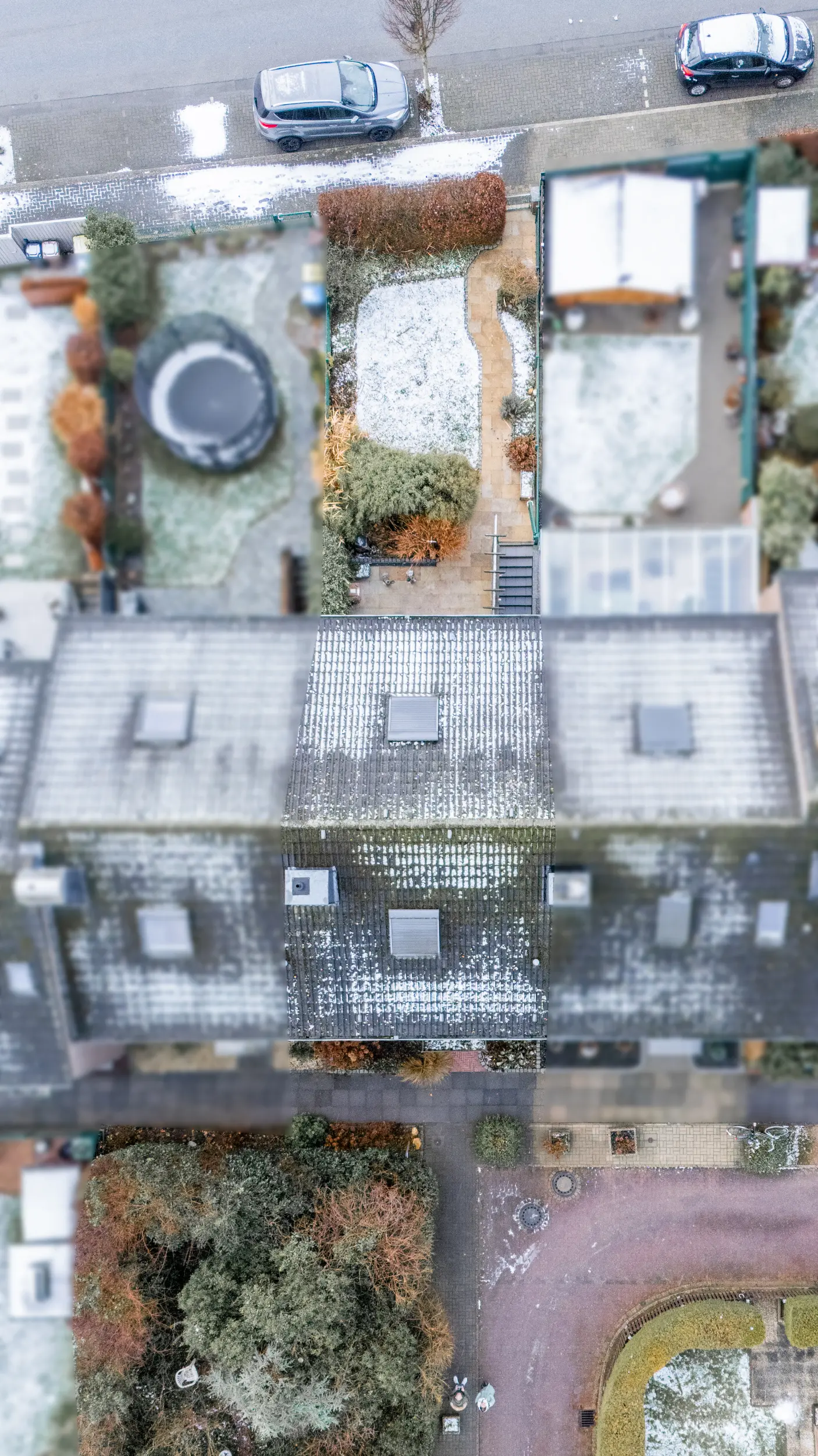 Schräge Luftaufnahme der Rückseite eines Reihenmittelhauses in Raesfeld mit Terrasse, Gartenfläche, Balkon und angrenzender Bebauung.