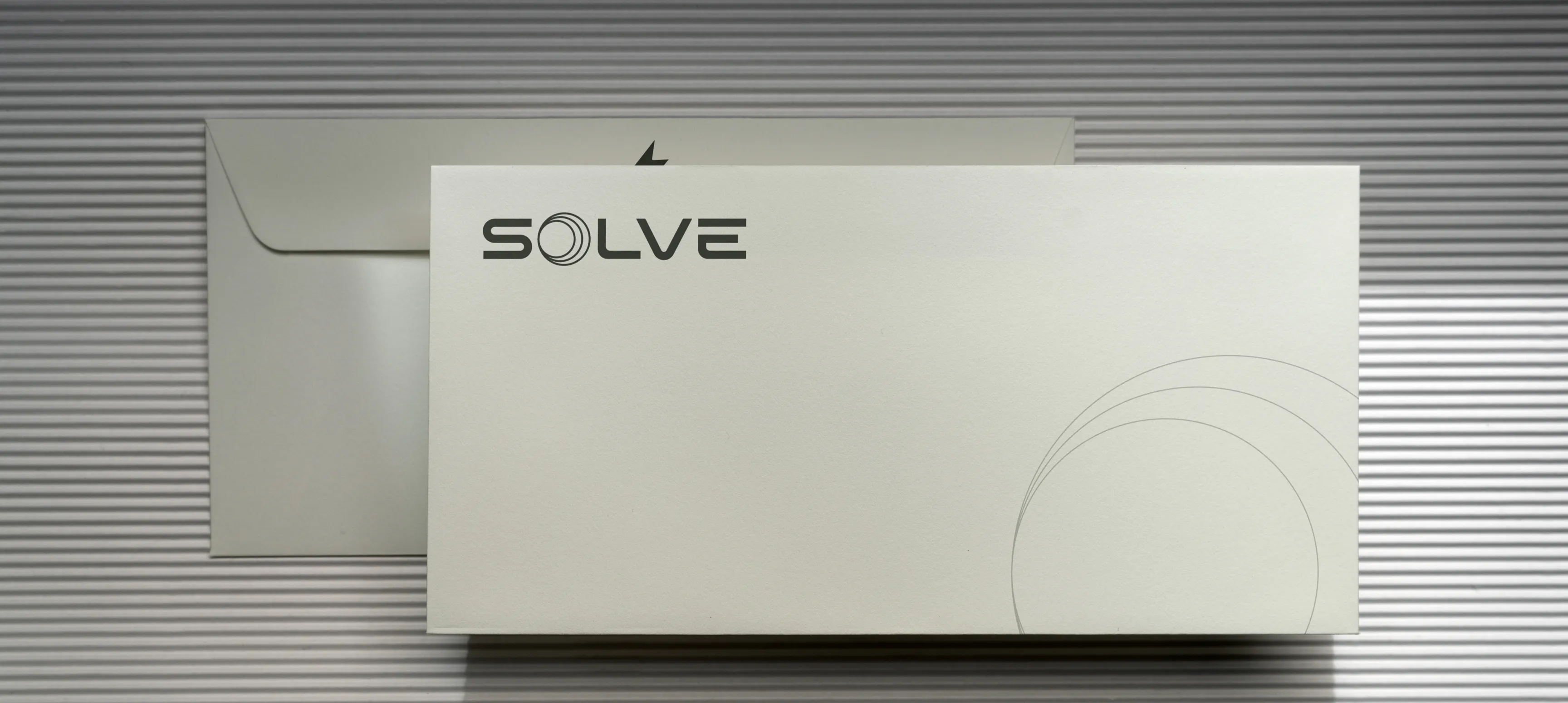 An envelope with Solve's logo and cascading circles lightly printed in the bottom right corner.