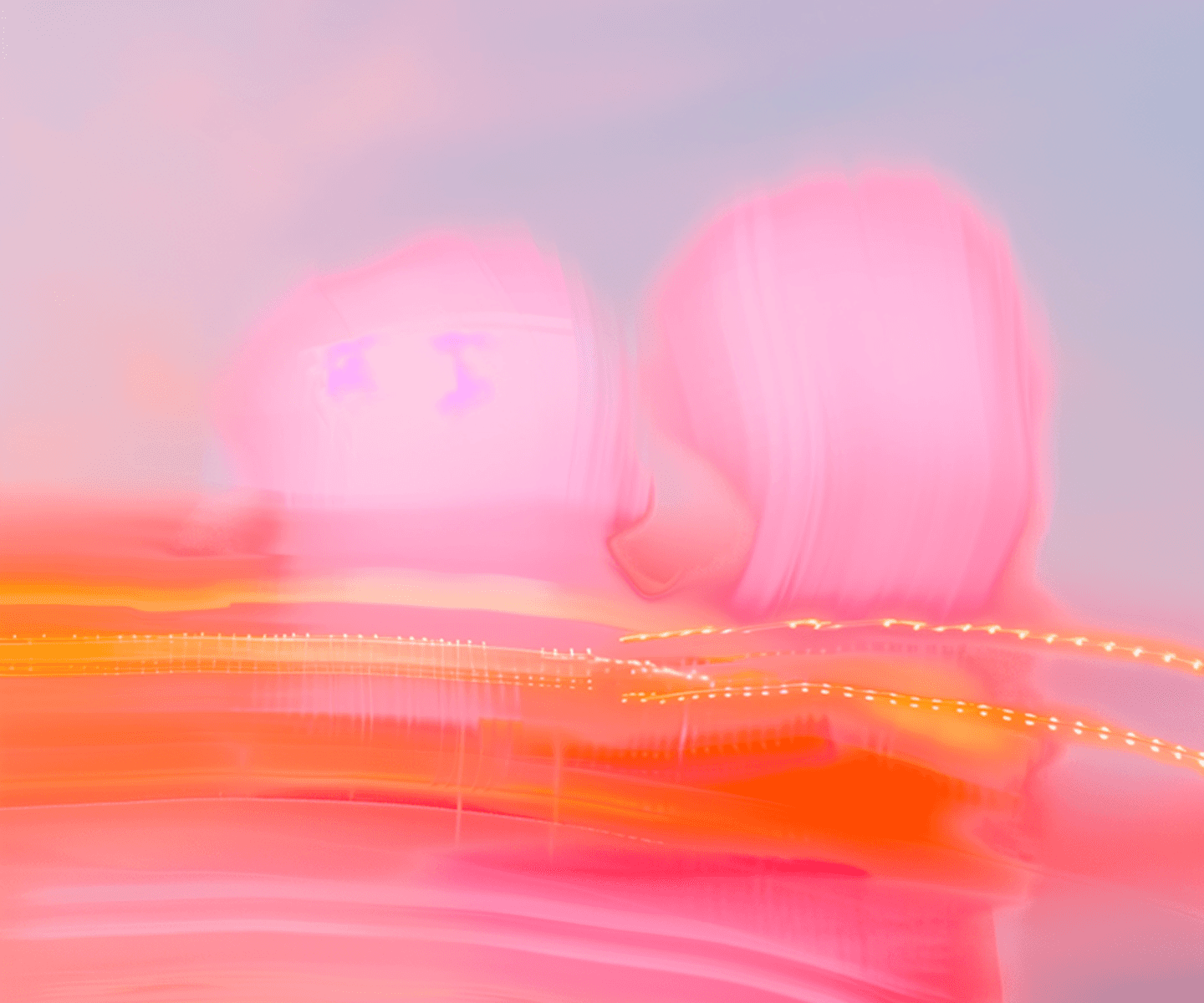 A pair of people in pink and purple outfits pose in front of a bright pink backdrop.