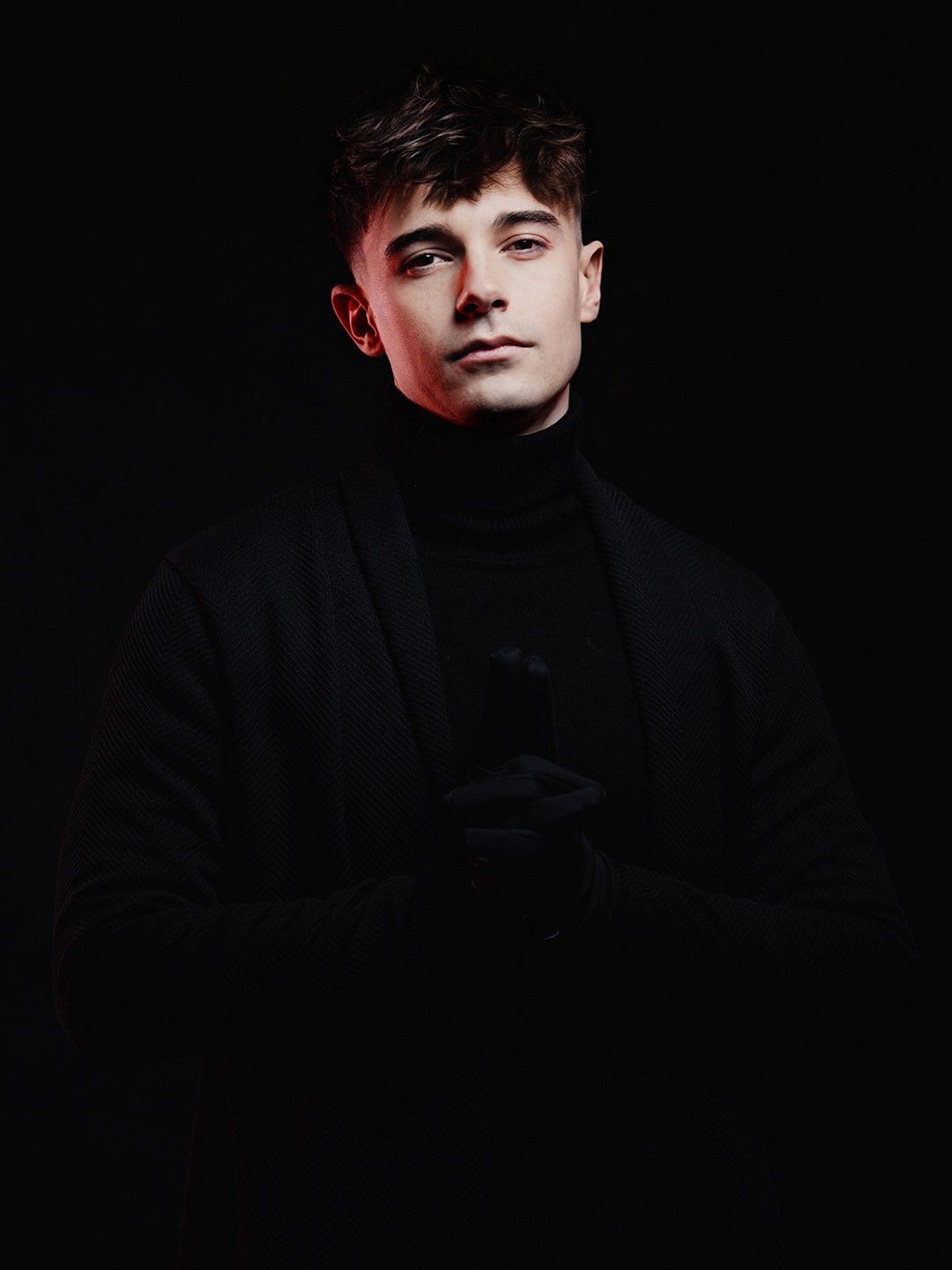 Portrait of a person in dark clothing speaking on a phone