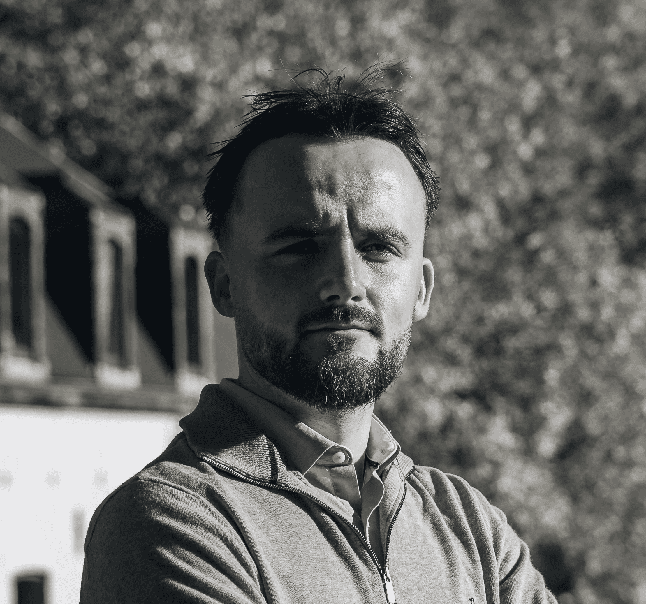 Portrait of a laughing person with curly hair wearing a white shirt