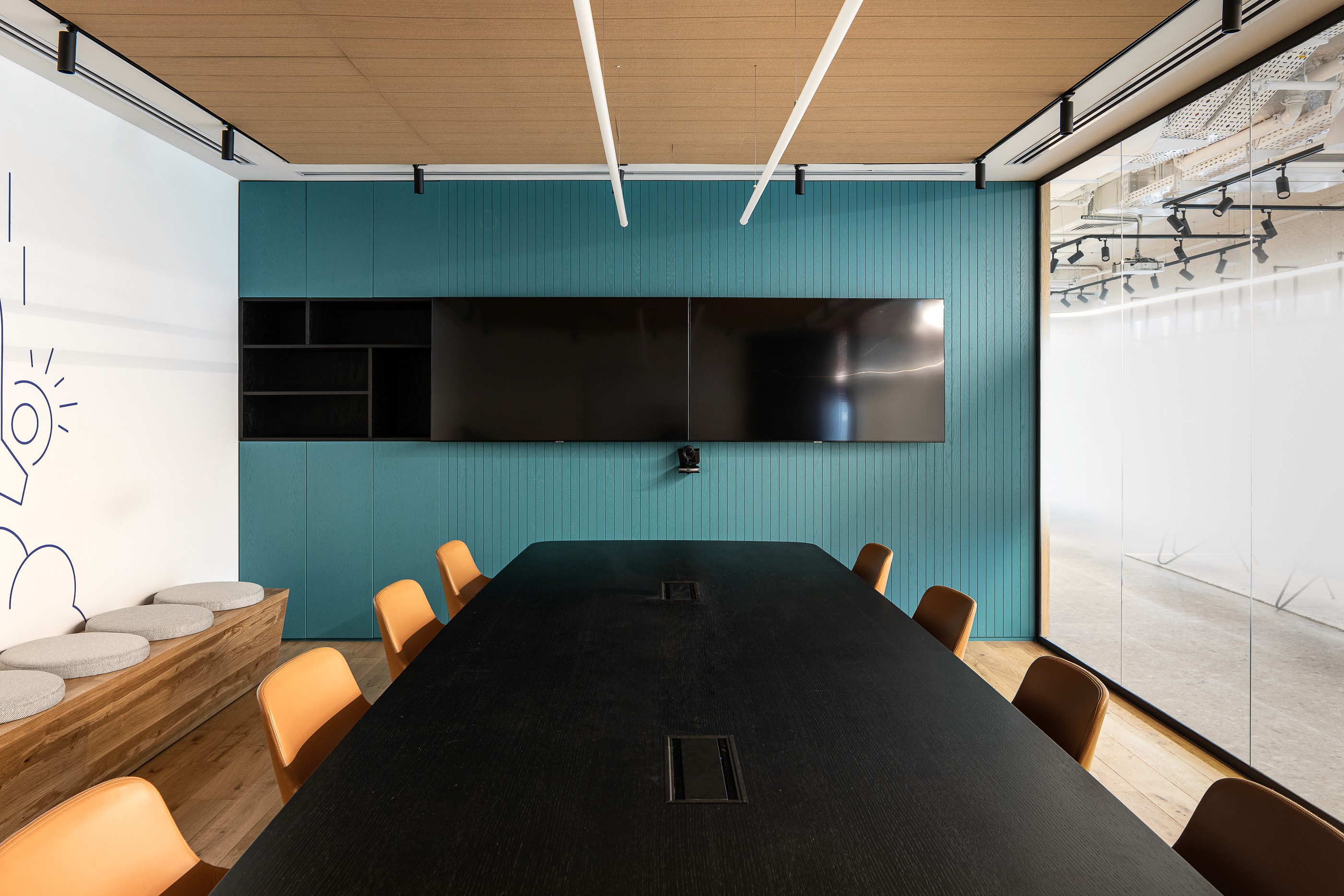 חדר ישיבות הנהלה (Boardroom): עיצוב המשלב קיר כוח בגוון כחול עמוק, שולחן ישיבות רחב ותקרה אקוסטית חשופה למראה תעשייתי-יוקרתי.