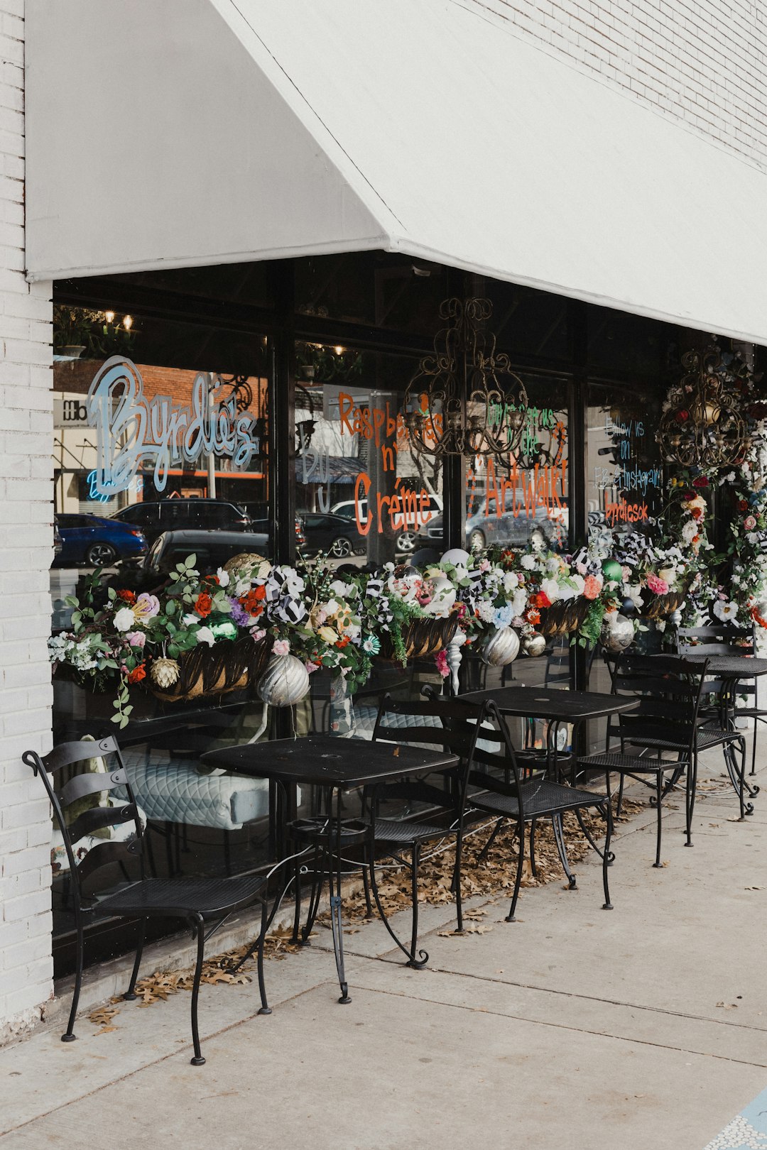tables and chairs outside of a flower shop