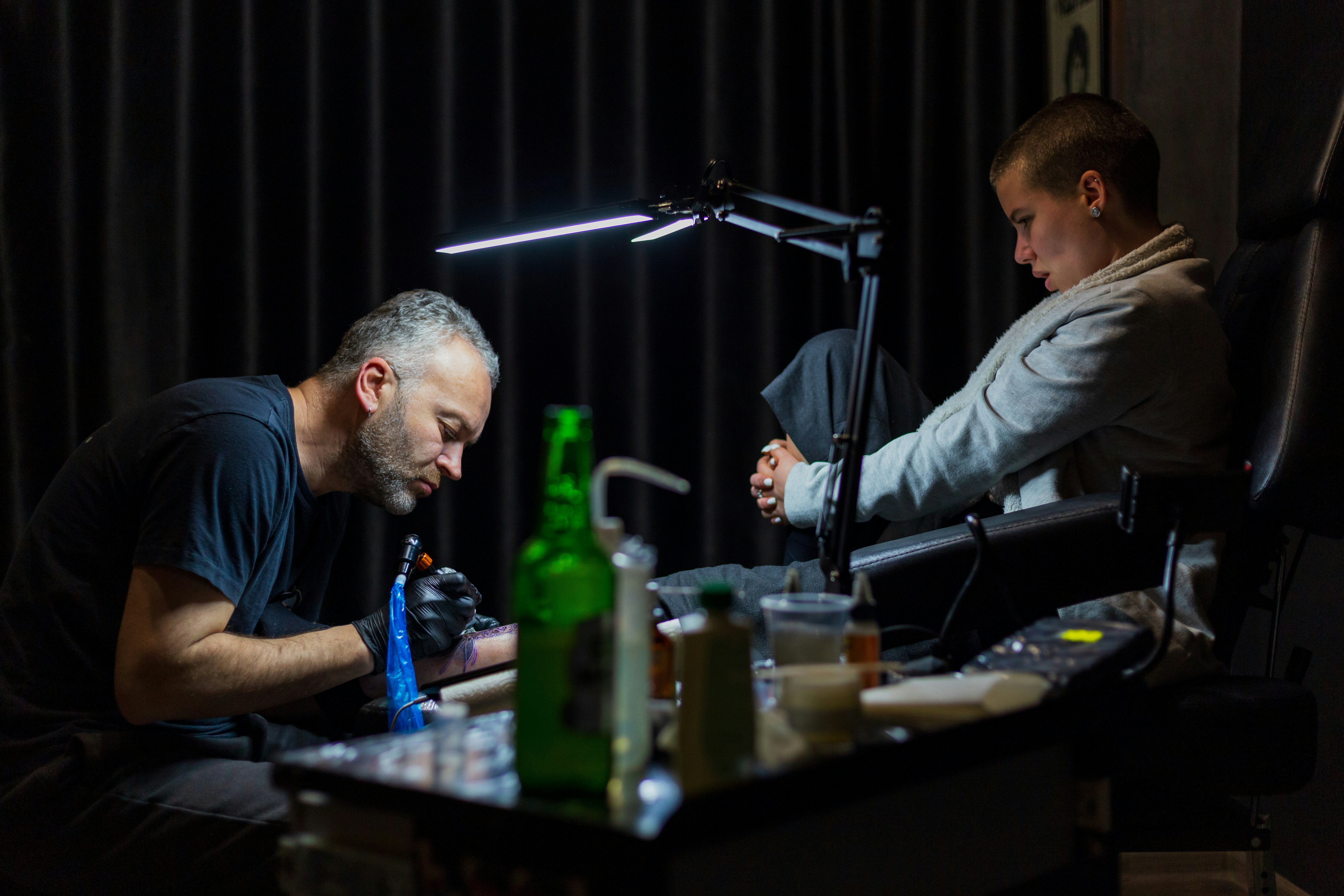 a man sitting in a chair next to another man