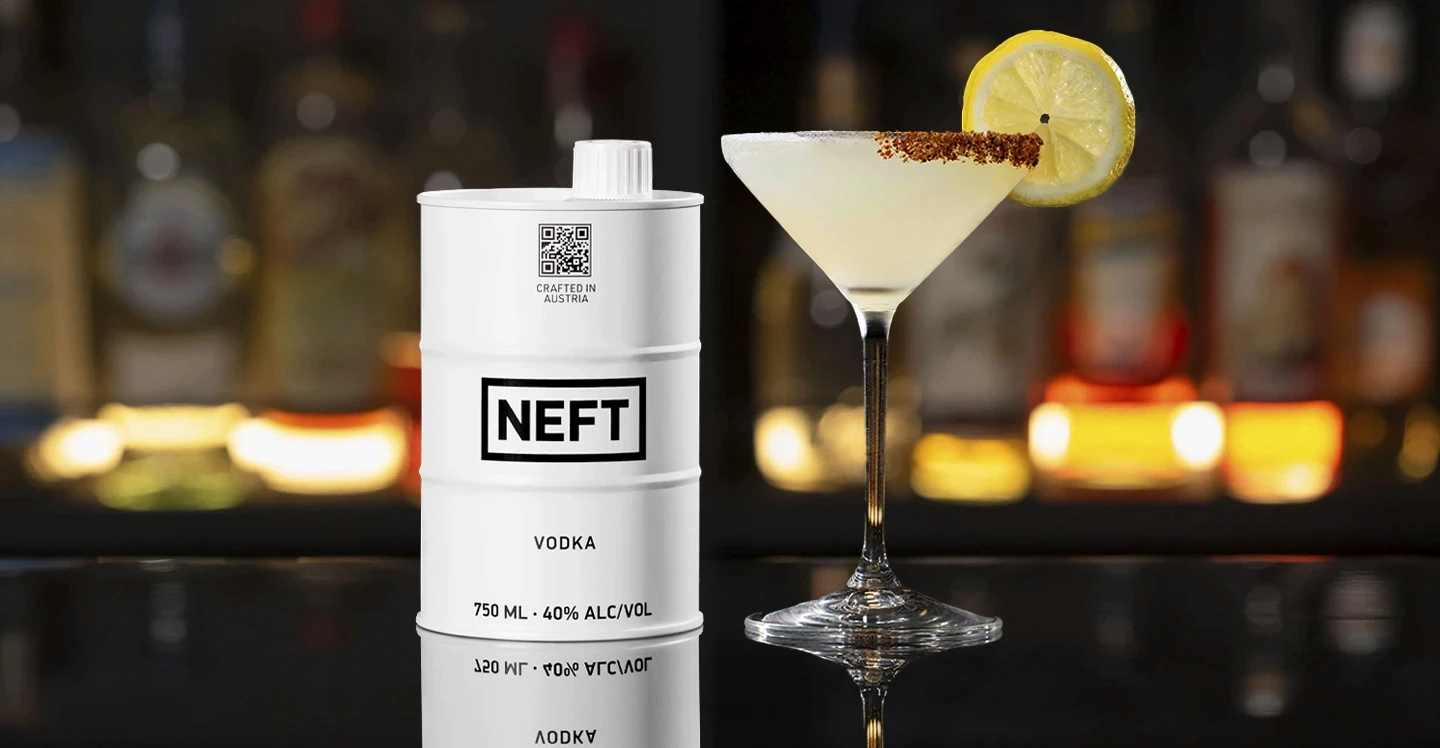 A NEFT Vodka Barrel and a glass of Lemon Drop on a bar counter.