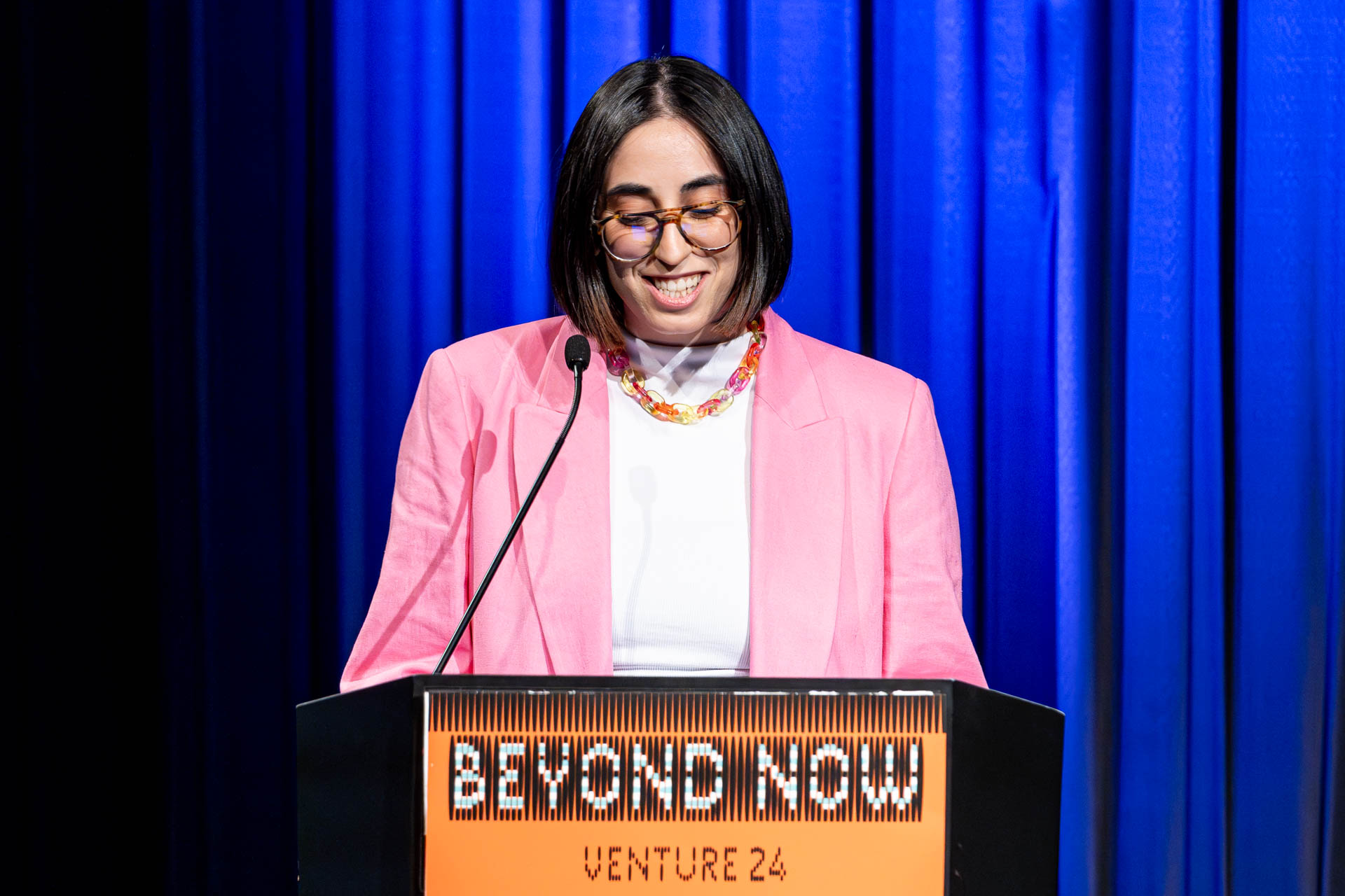 a student at a podium presenting a project in a Theatre