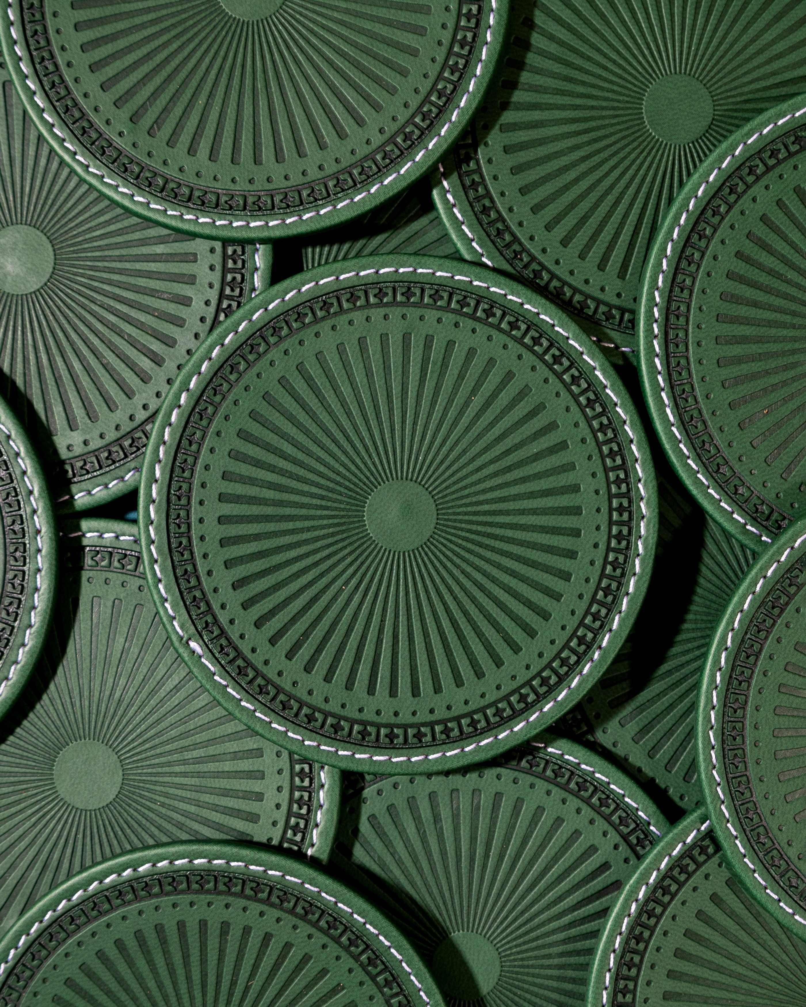 Close-up of a yellow tennis ball sitting on a green court, positioned near the white center line.